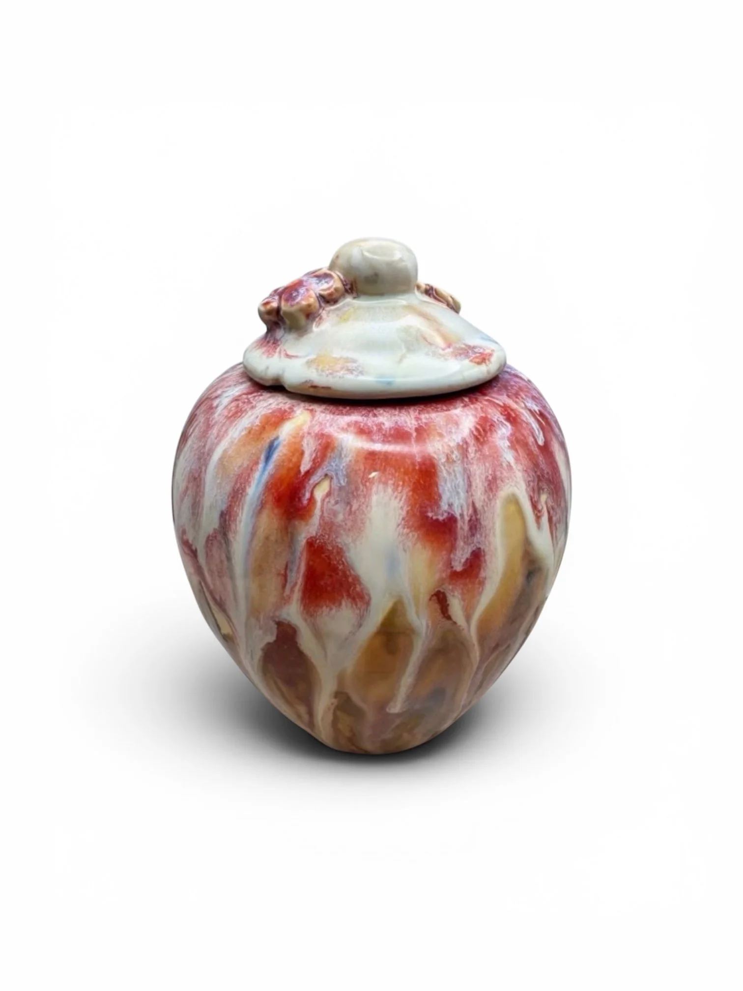 Marbled ceramic vase with a lid, featuring swirls of red, yellow, and cream colors against a white background.