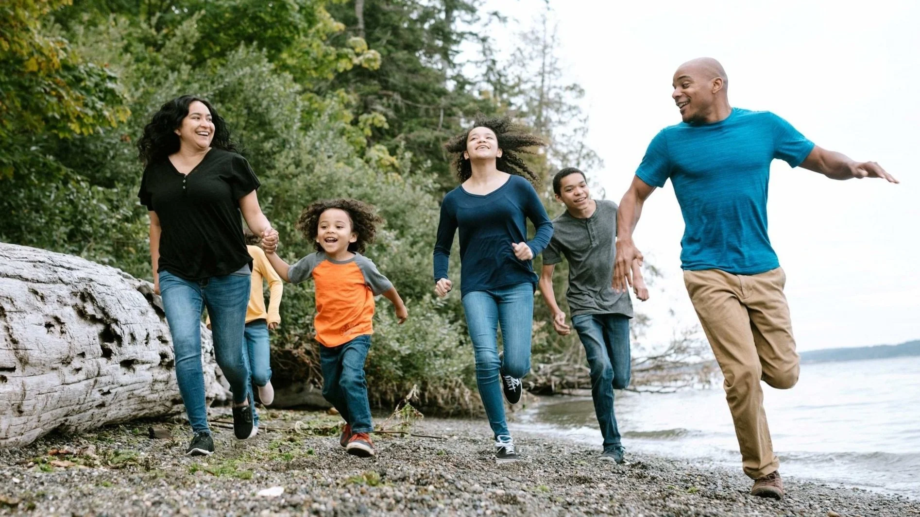 Photo of family running by a lake.