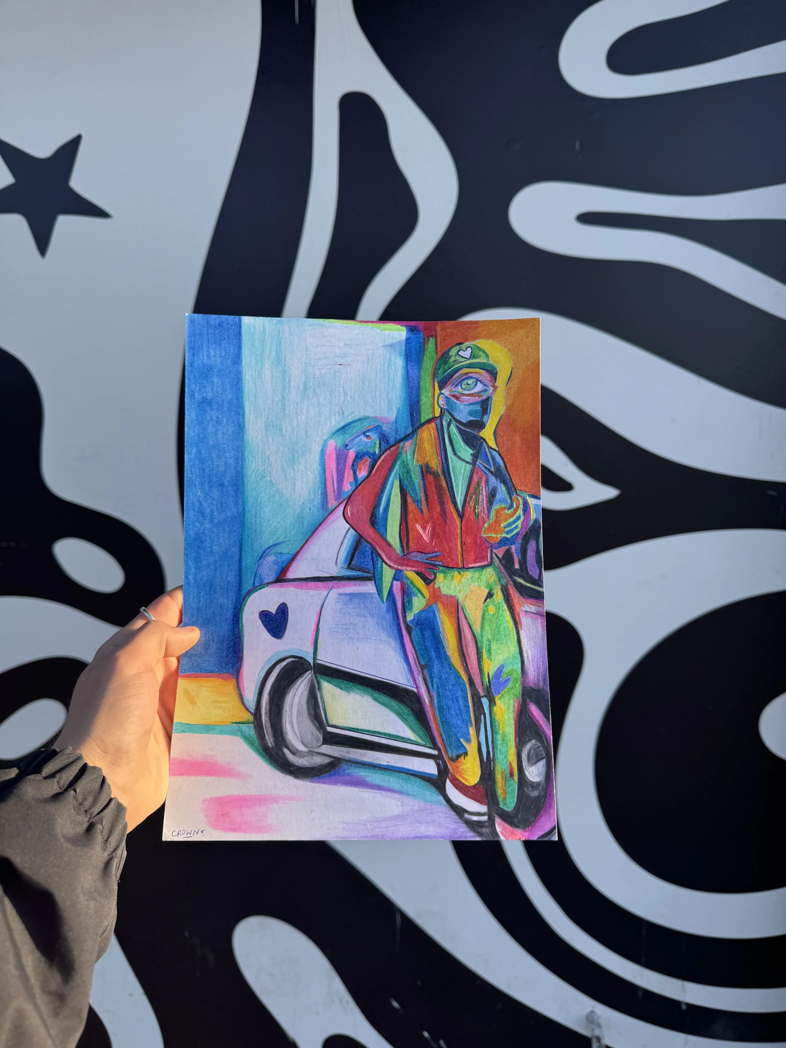 Photo d’une œuvre contemporaine colorée tenue à la main par l’artiste Crown*