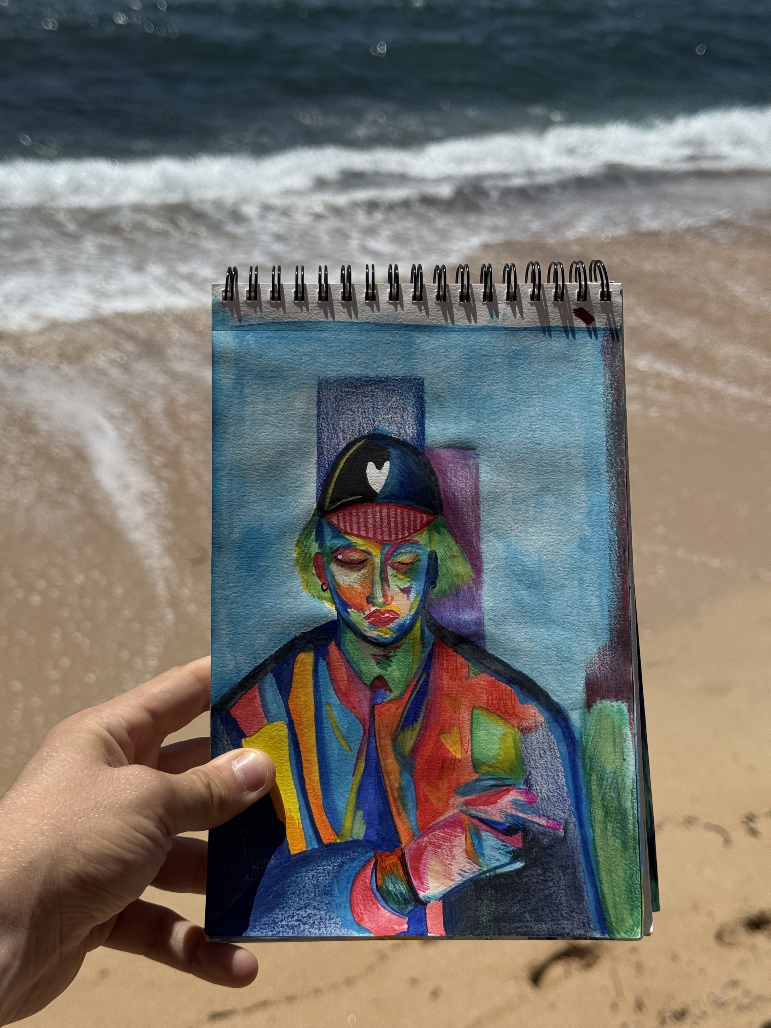 Œuvre contemporaine colorée de Crown* présentée au bord de l'eau sur une plage