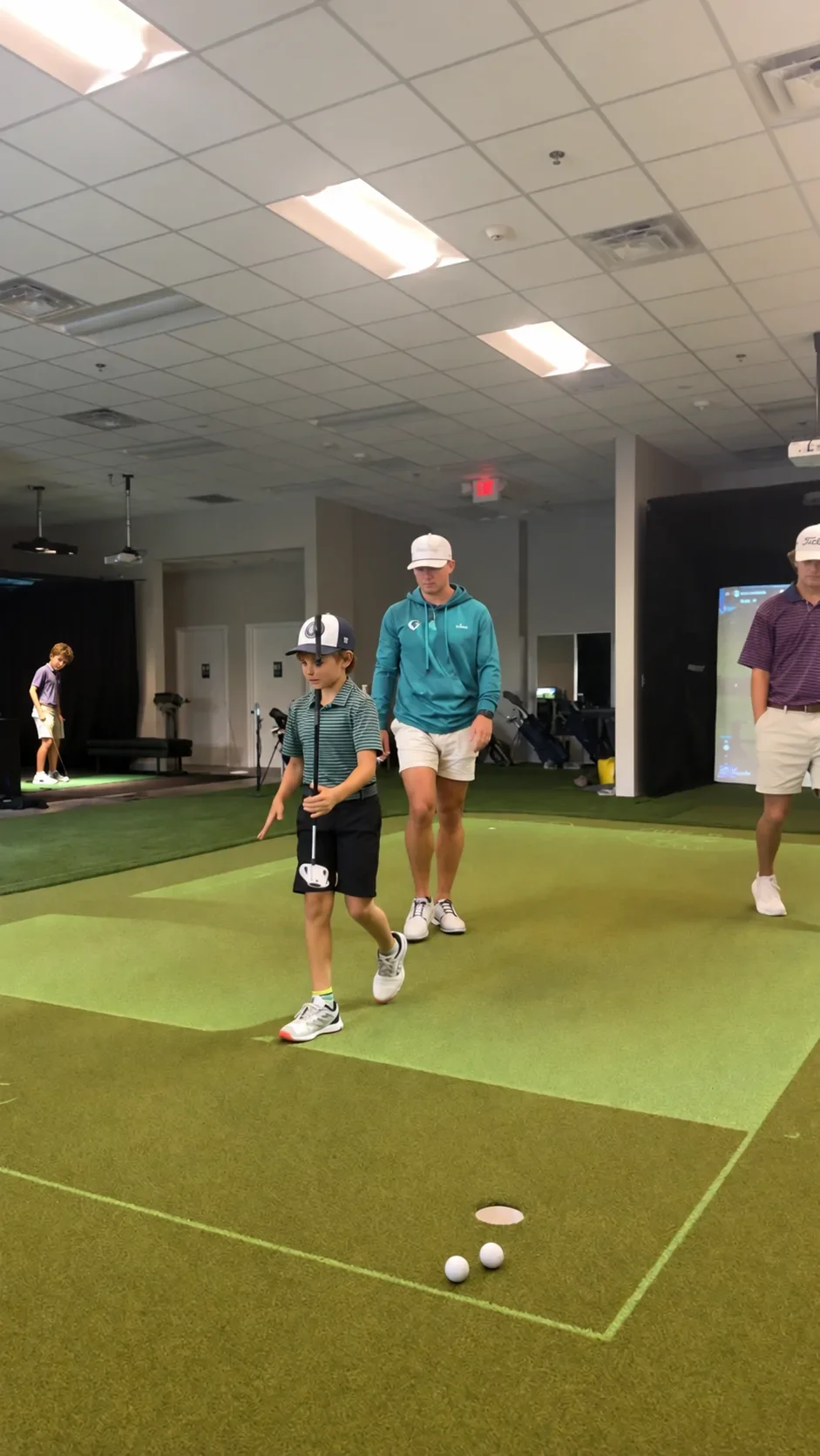 Junior golfers taking part in group instruction in Coastal Golf Academy's PuttView area