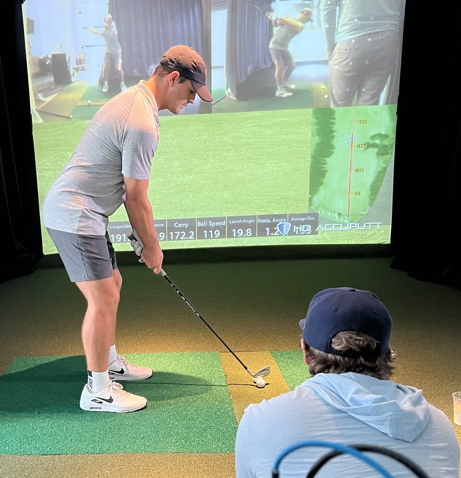 Ethan Castle observing a golfer during a simulator lesson