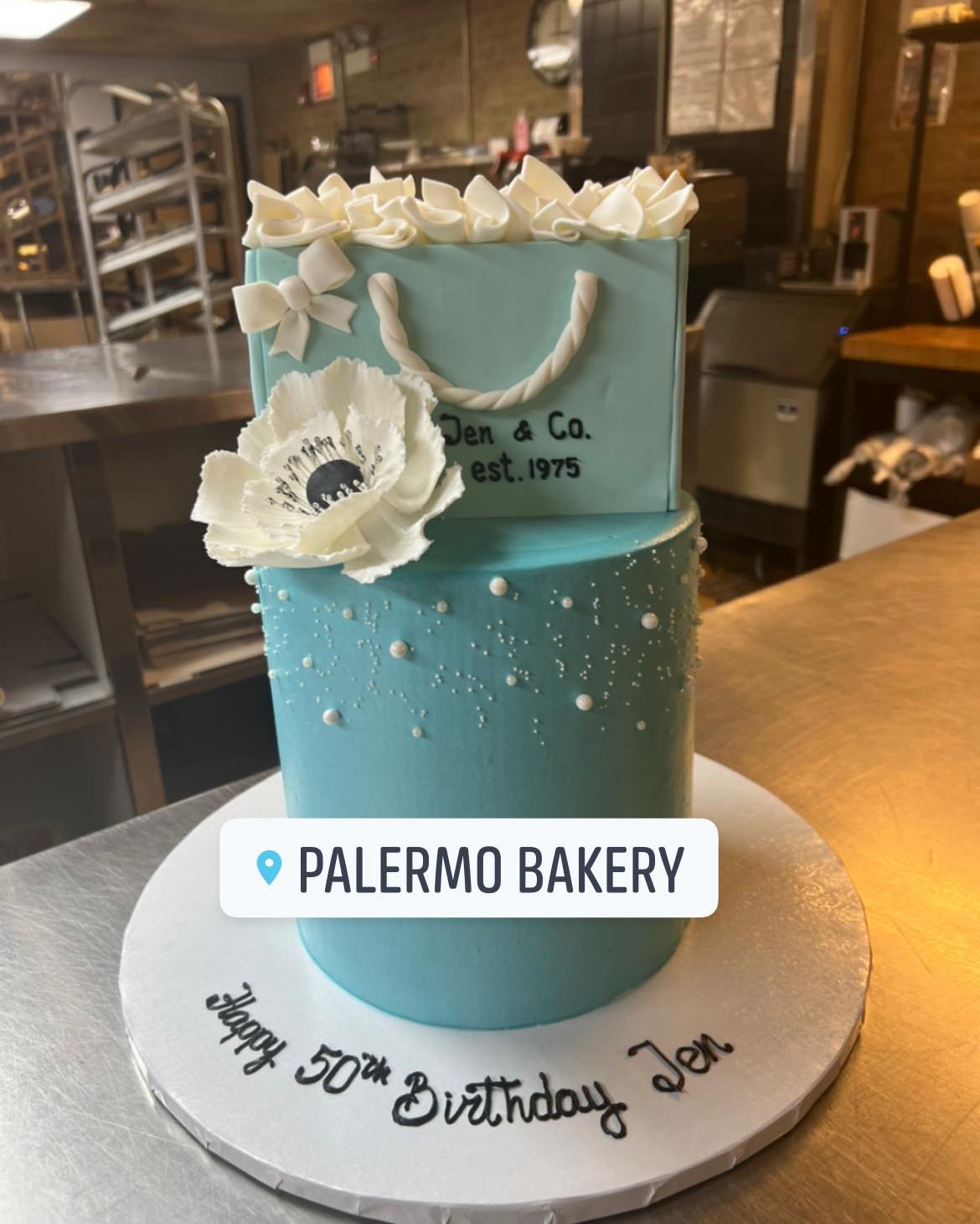 Elegant Designer-Inspired Birthday Cake
Celebrate in style with this Tiffany & Co.-inspired two-tier cake, featuring a signature blue finish, sugar pearls, and a sculpted gift bag topper with handmade details. Perfect for a chic 50th birthday or