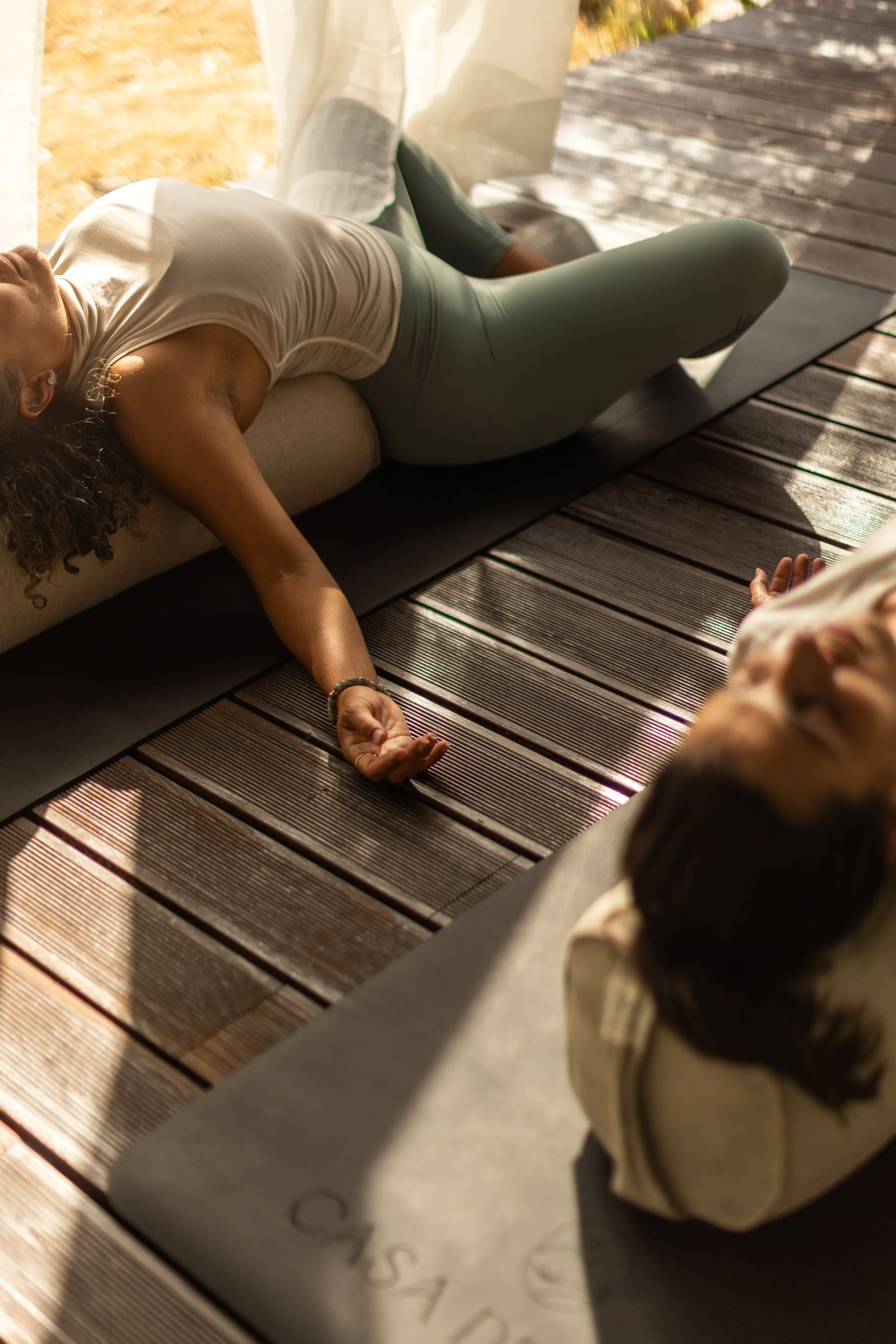Woman practising yoga in an open-air shala surrounded by olive trees and mountain views at a women’s yoga retreat in the Algarve, Portugal.