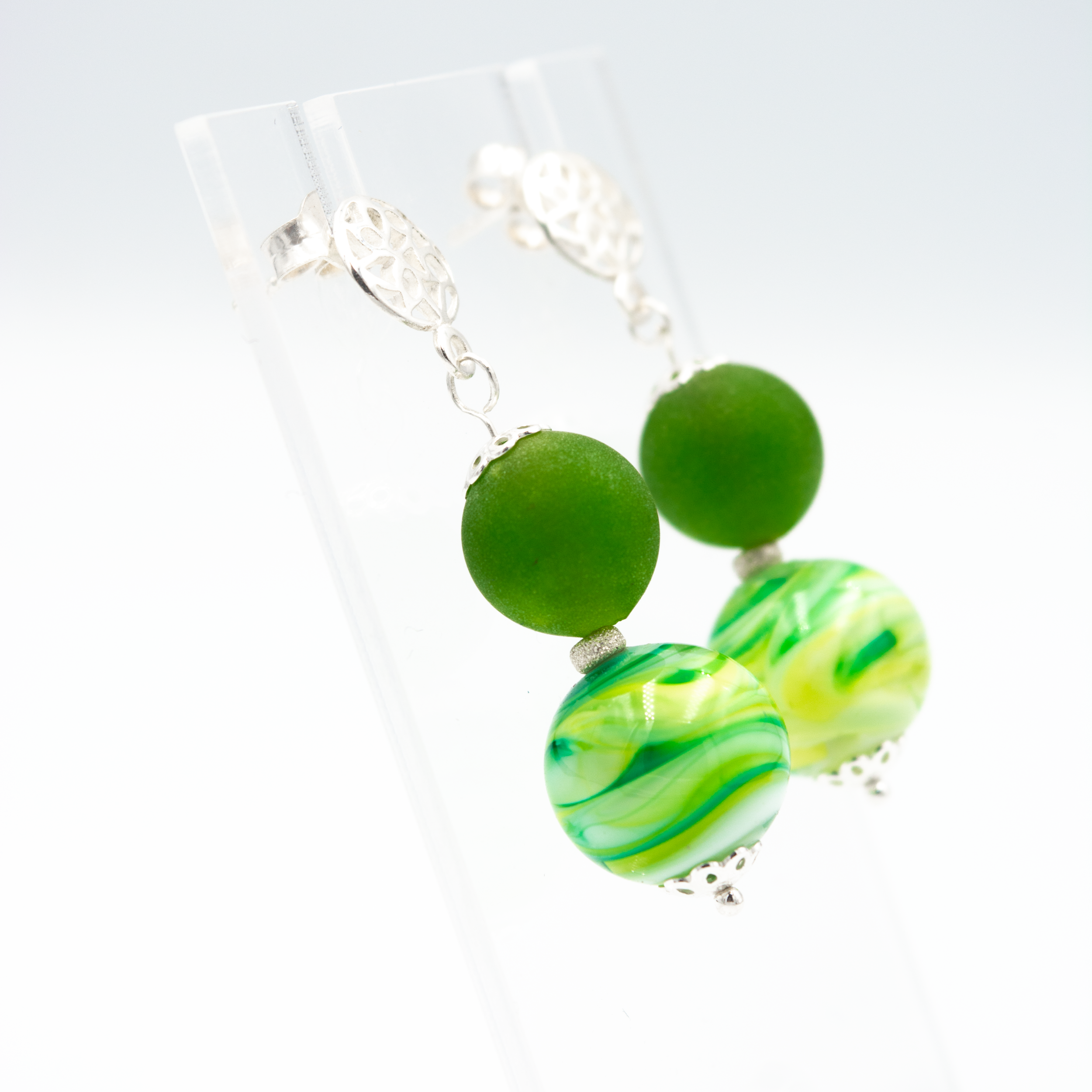 Detalle de pendientes Libélula Verde hechos a mano en vidrio de Murano con matices naturales y plata de ley.