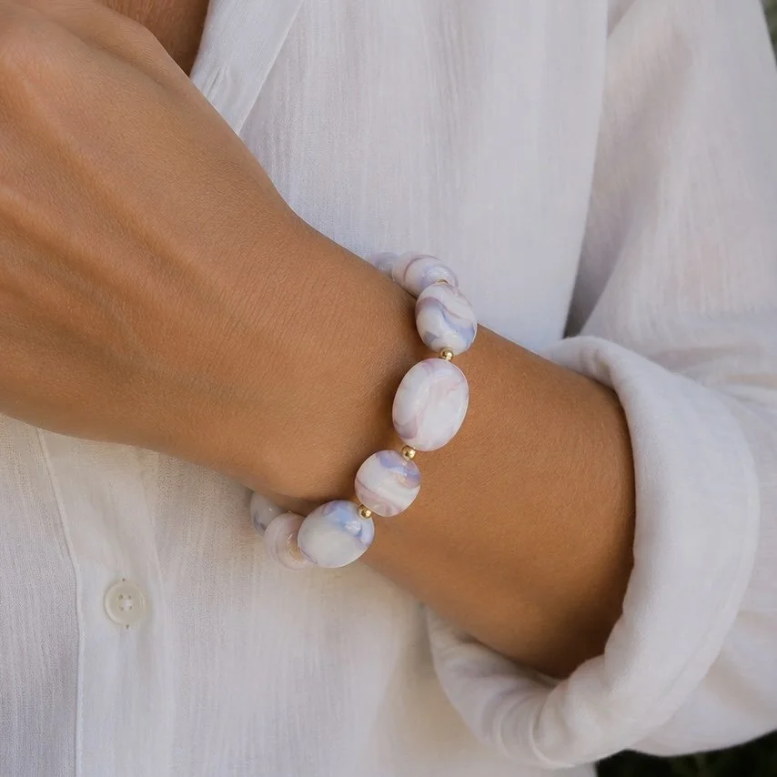 Mujer llevando pulsera Ramé Oro de vidrio de Murano artesanal y plata de ley con elegantes matices suaves.