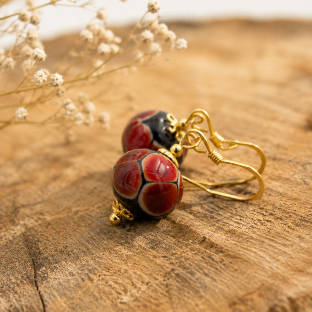 Detalle de pendientes Rubí hechos a mano en vidrio de Murano con matices rojizos y plata de ley.