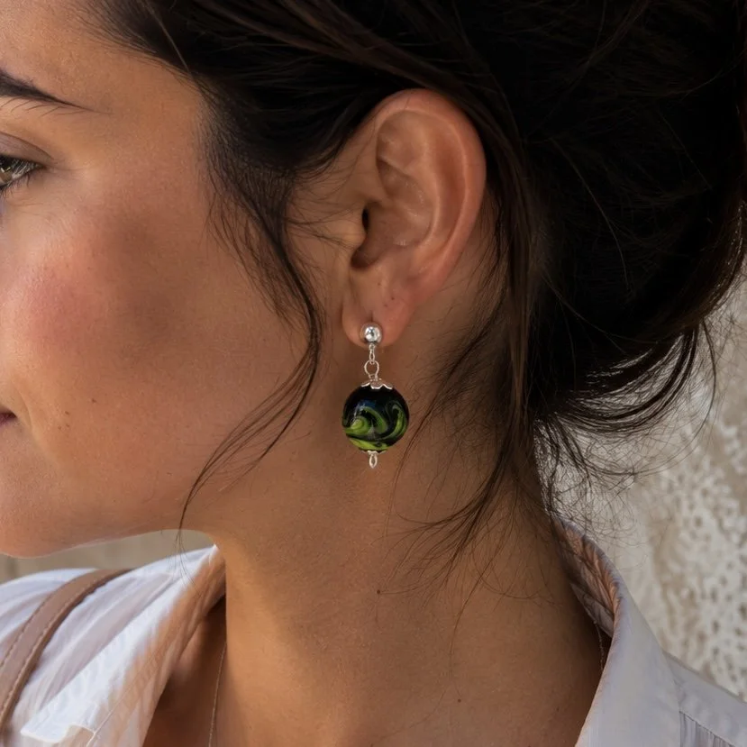 Mujer llevando pendientes Marble Verde de vidrio de Murano artesanal y plata de ley inspirados en la naturaleza.