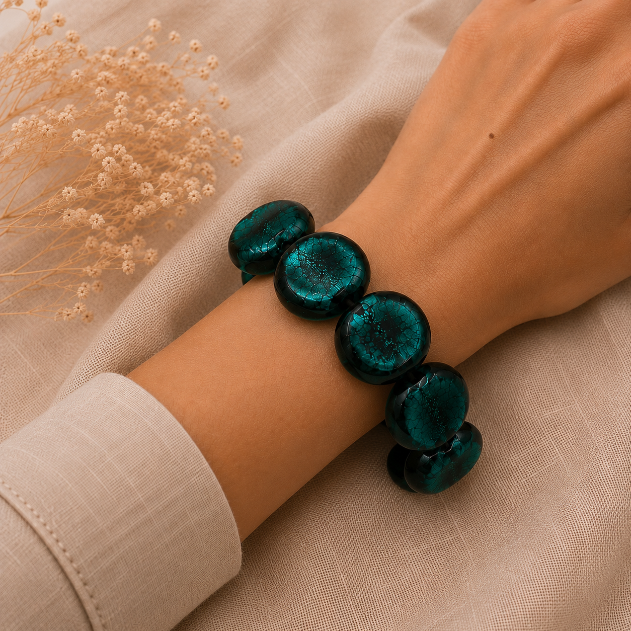 Mujer llevando pulsera Lagoon de vidrio de Murano artesanal y plata de ley con reflejos acuáticos luminosos.