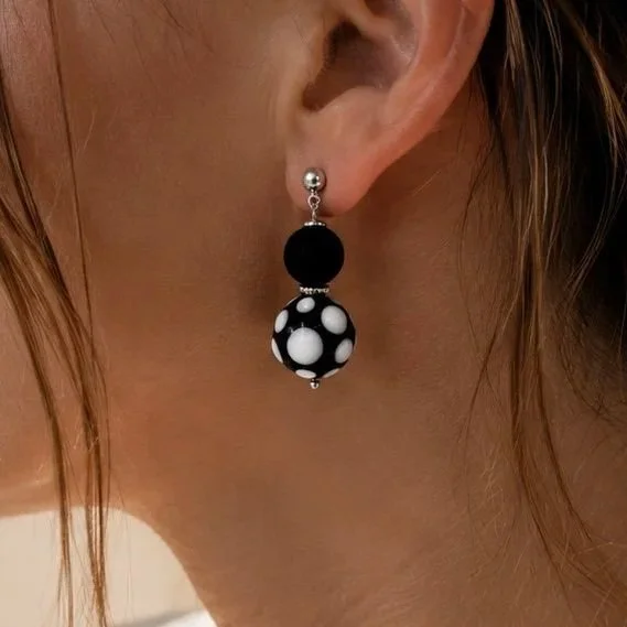 Mujer llevando pendientes Real Negro de vidrio de Murano artesanal y plata de ley con estilo sofisticado y atemporal.