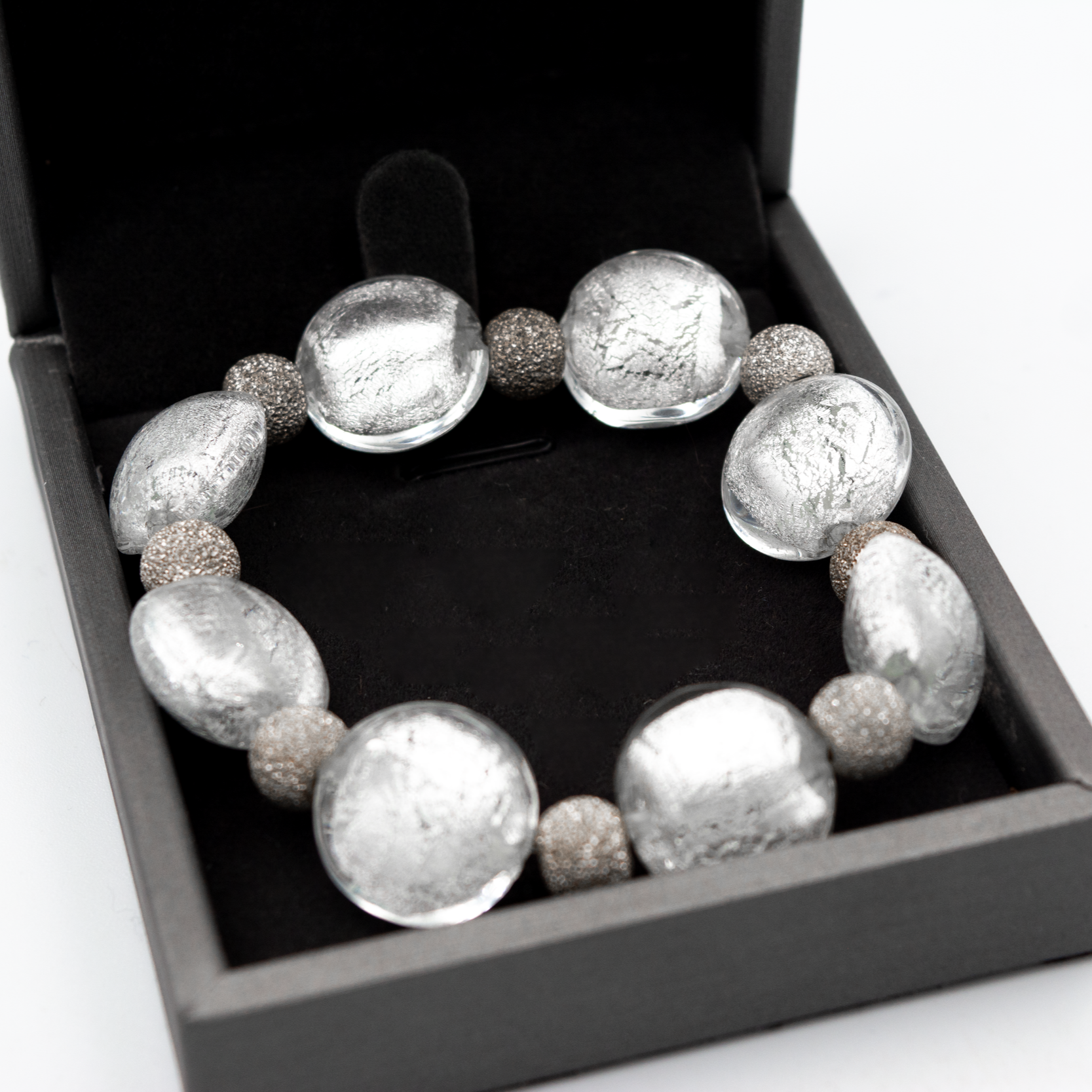 Detalle de pulsera Argento hecha a mano en vidrio de Murano con reflejos plateados y plata de ley.