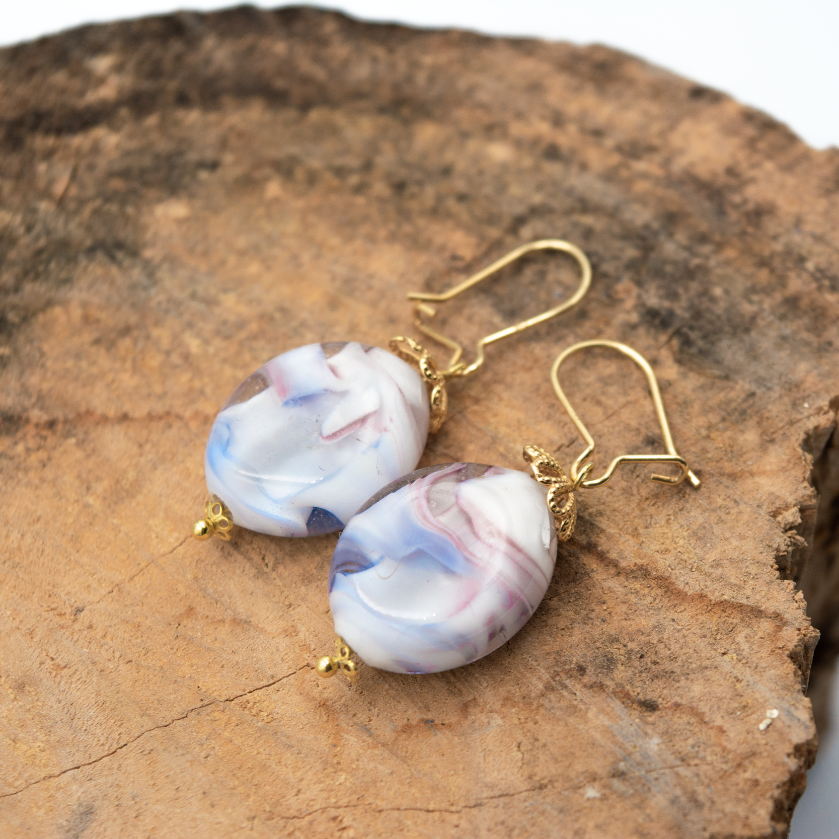 Detalle de pendientes Ramé Oro hechos a mano en vidrio de Murano con tonos pastel y plata de ley.