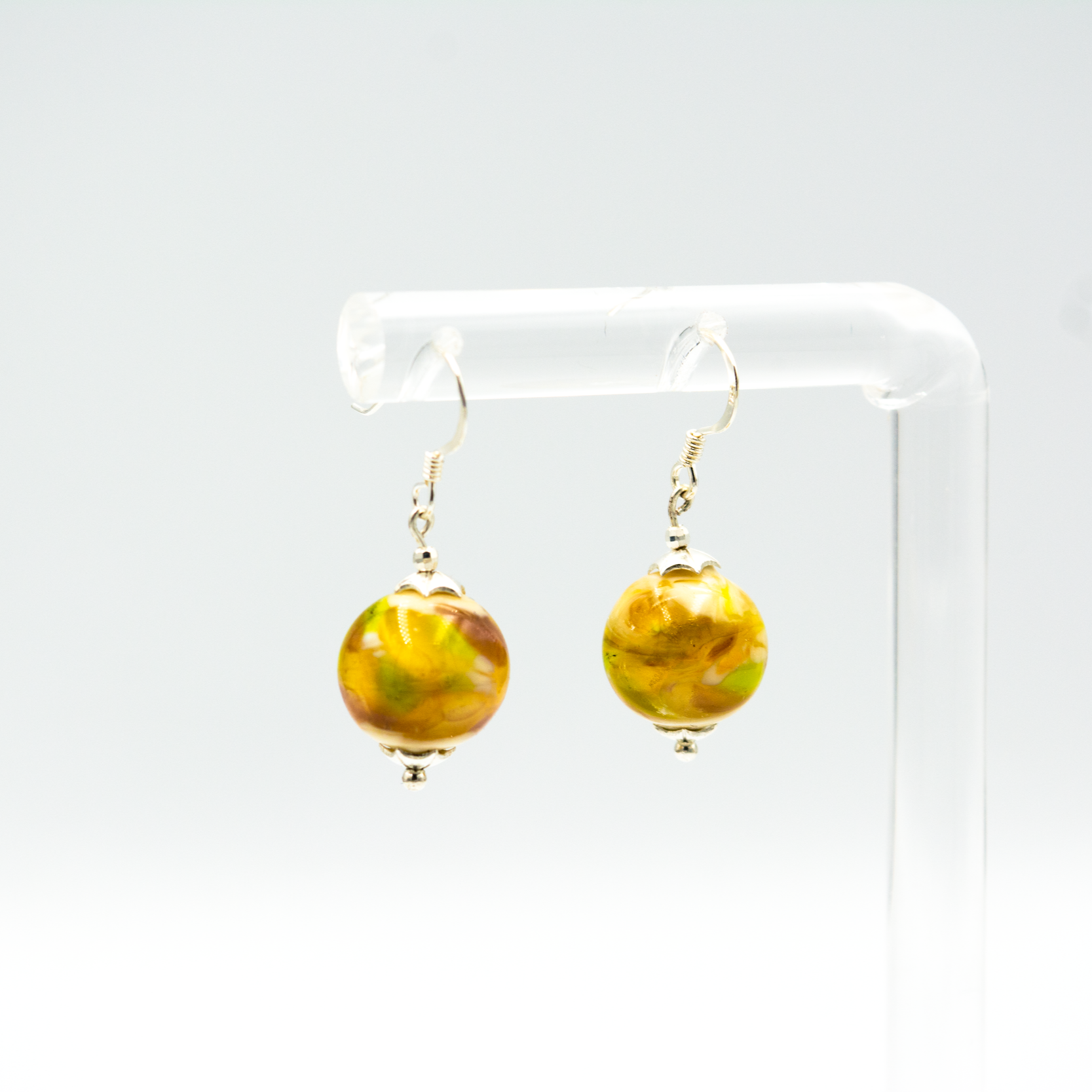 Detalle de pendientes Kairos hechos a mano en vidrio de Murano con reflejos únicos y plata de ley.