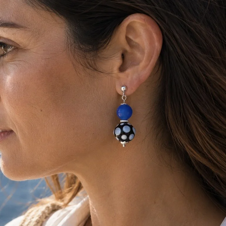 Mujer llevando pendientes Real Azul de vidrio de Murano artesanal y plata de ley con elegantes reflejos azul profundo.