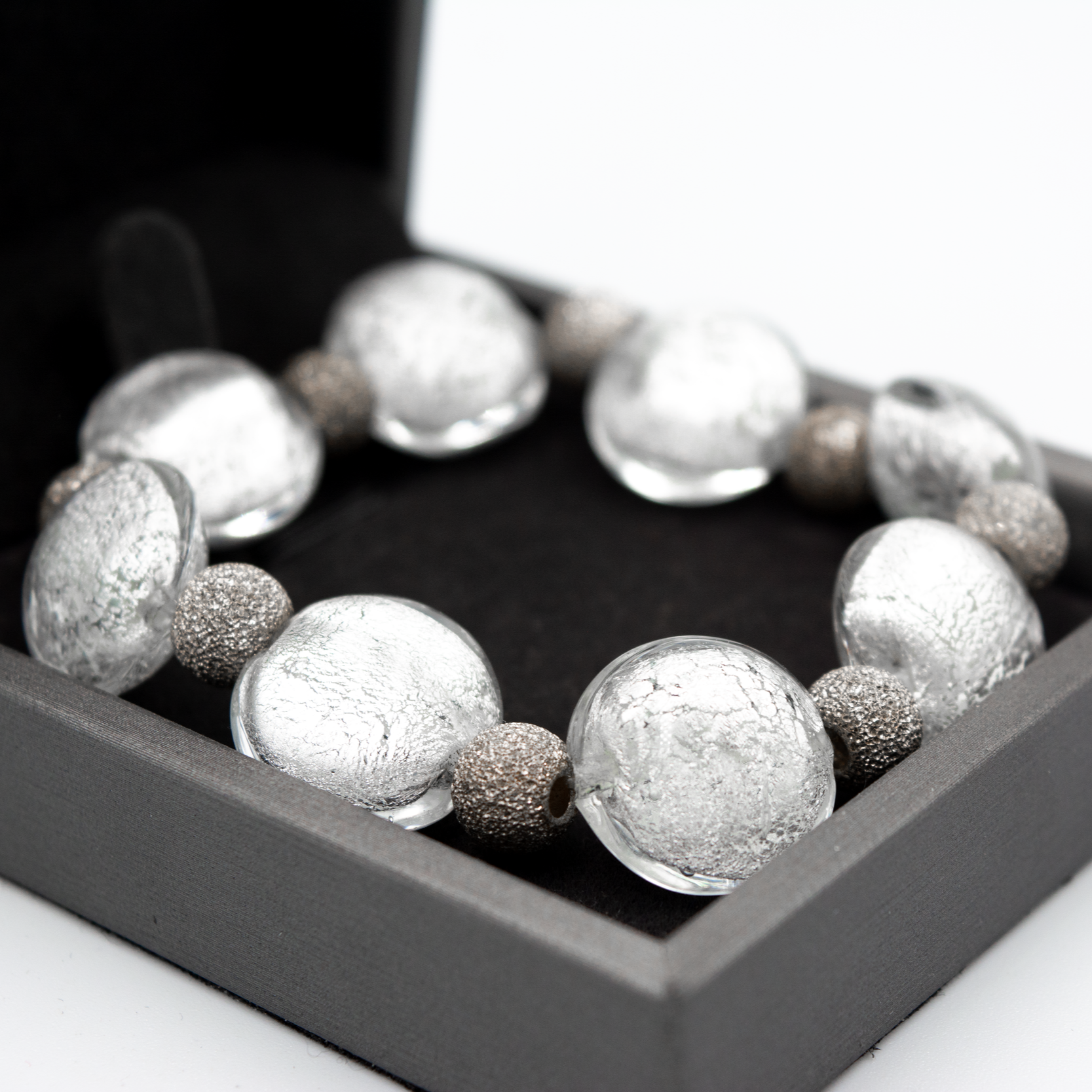 Detalle de pulsera Argento hecha a mano en vidrio de Murano con reflejos plateados y plata de ley.
