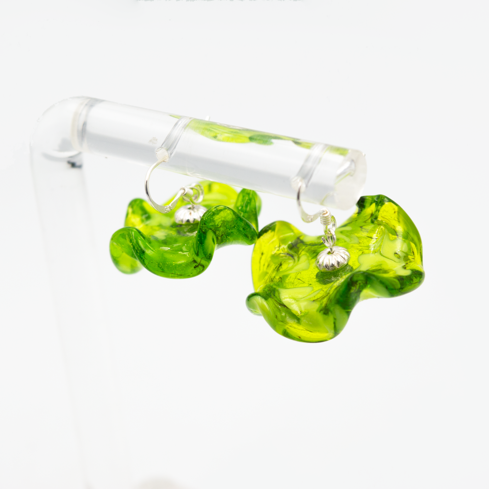Detalle de pendientes Onde Verde hechos a mano en vidrio de Murano con matices naturales y plata de ley.