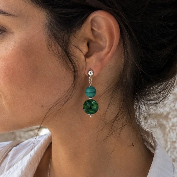 Mujer llevando pendientes Libélula Oliva de vidrio de Murano artesanal y plata de ley con diseño inspirado en libélulas.