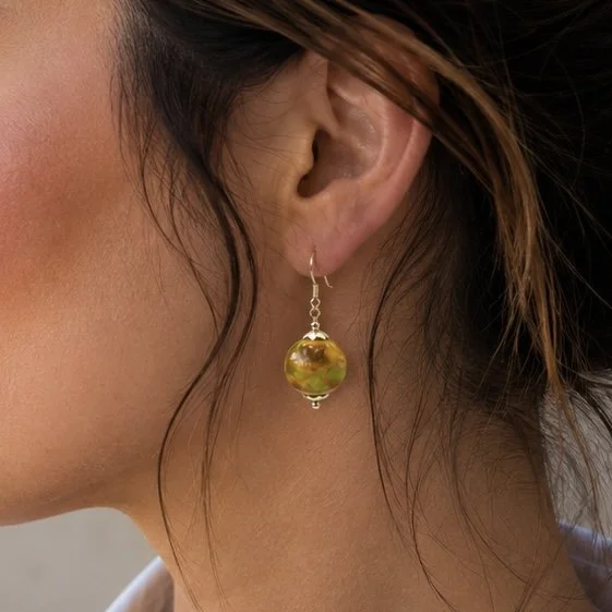 Mujer llevando pendientes Kairos de vidrio de Murano artesanal y plata de ley con estilo sofisticado.
