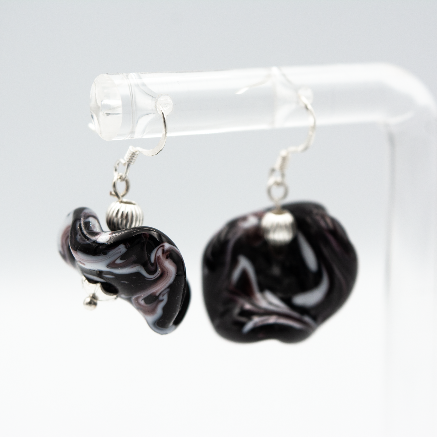 Detalle de pendientes Onde Negro hechos a mano en vidrio de Murano con brillo profundo y plata de ley.