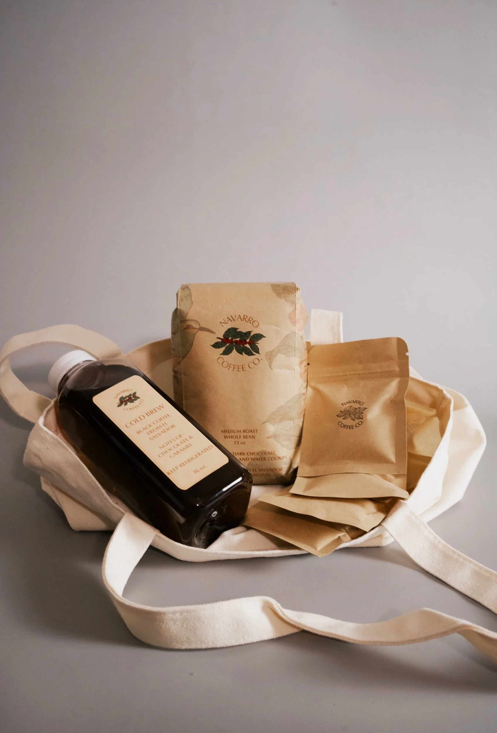 A 12 oz bag of coffee, 16 oz cold brew bottle, 4 packs of hot chocolate and an organic tote bag