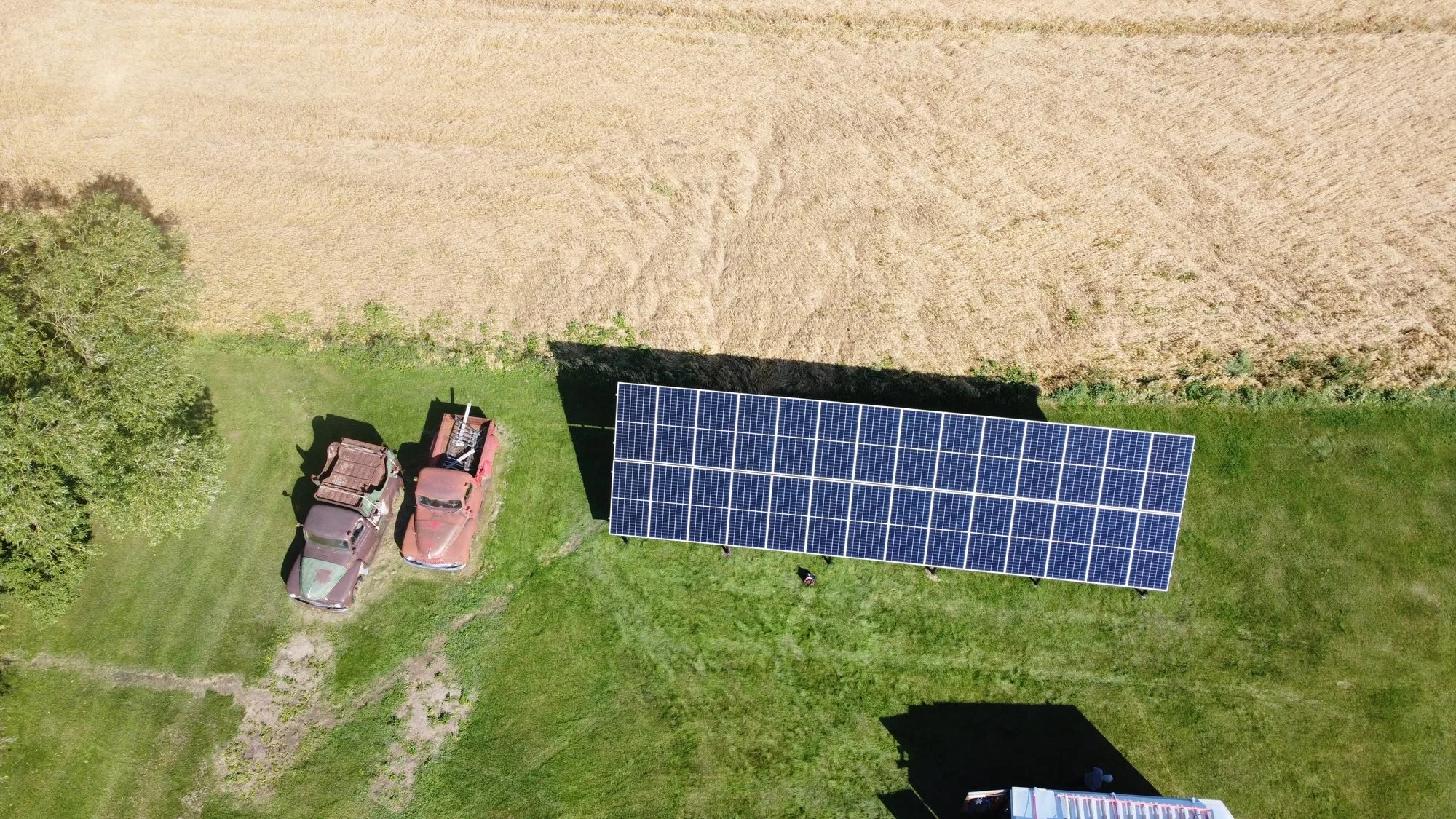 Ground-mount solar array beside a field on a farm in Sturgeon County, Alberta, installed by Greenamp