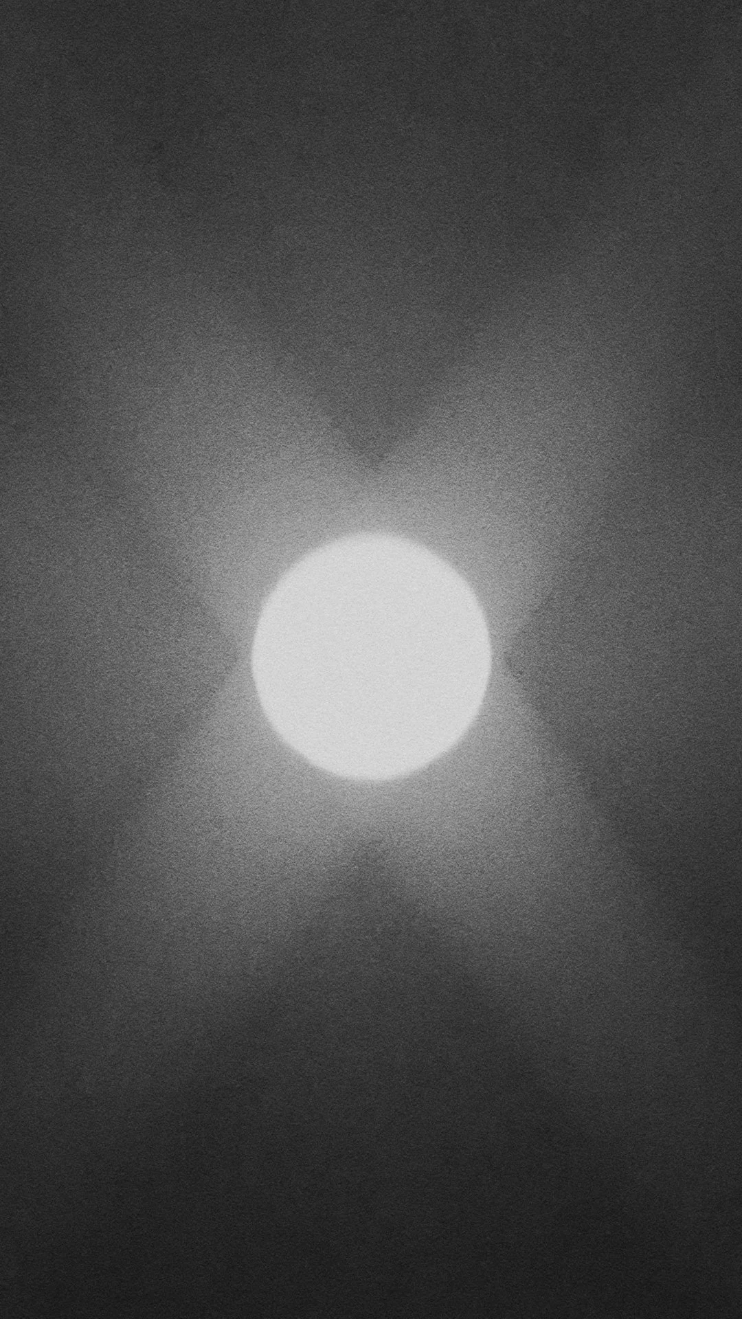 Black and white photo of the sun with shadows or glare.