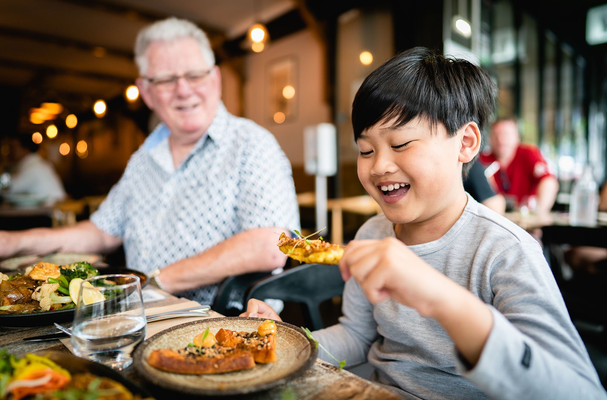  two people enjoying prawn toast with sesame, shallot, ginger serve with XO mayo 