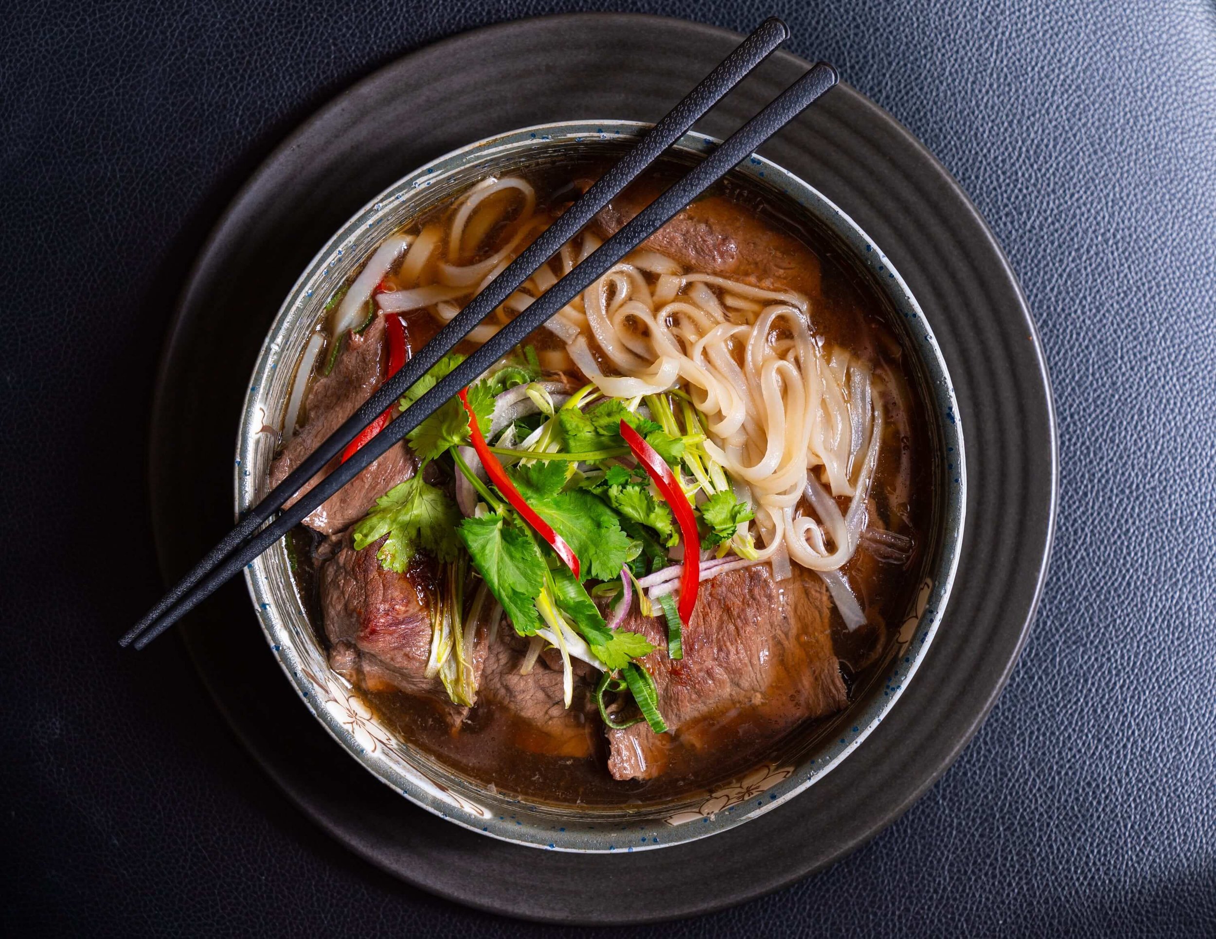  beef noodle soup with fresh herbs and chilli 