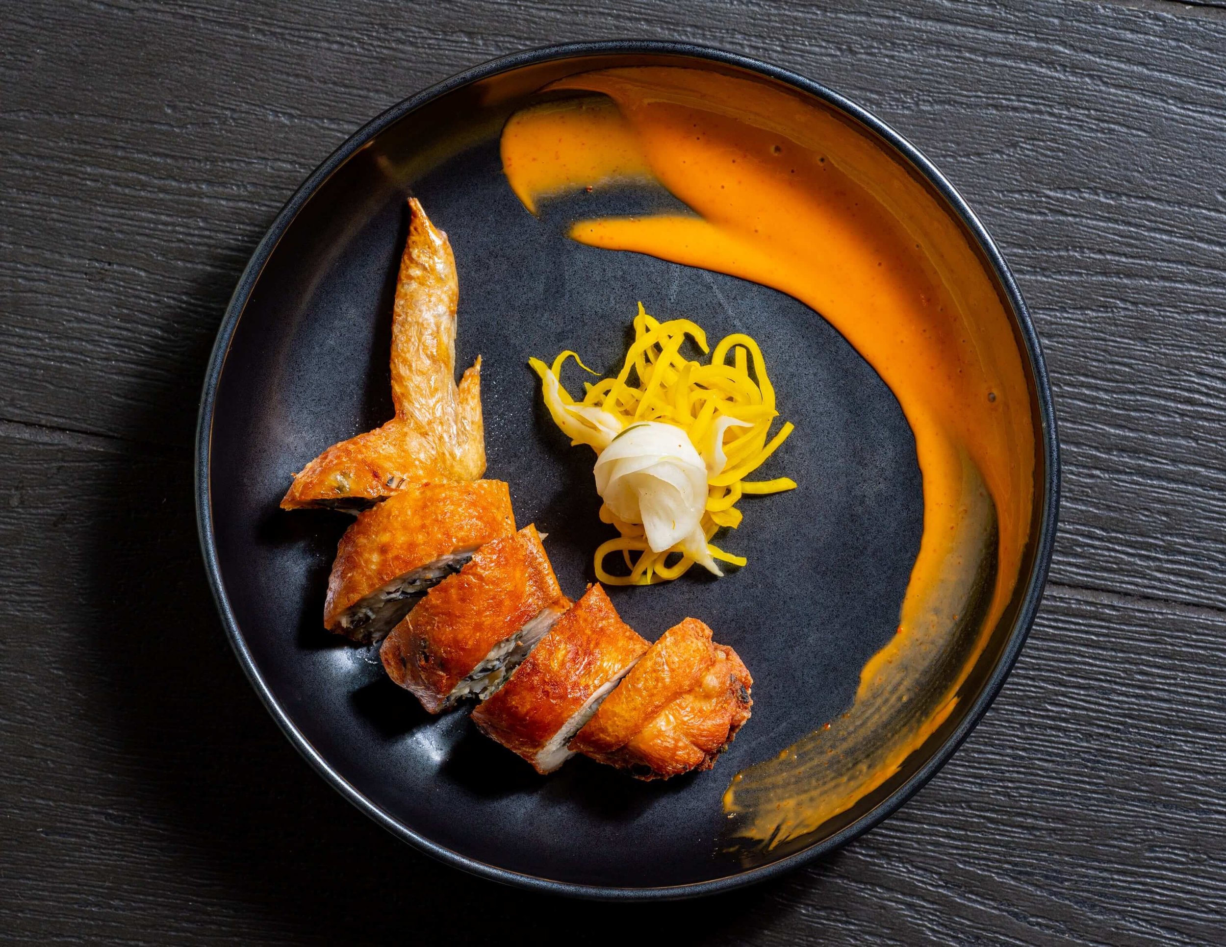  Beautifully plated duck with a swirl of brightly coloured sauce   