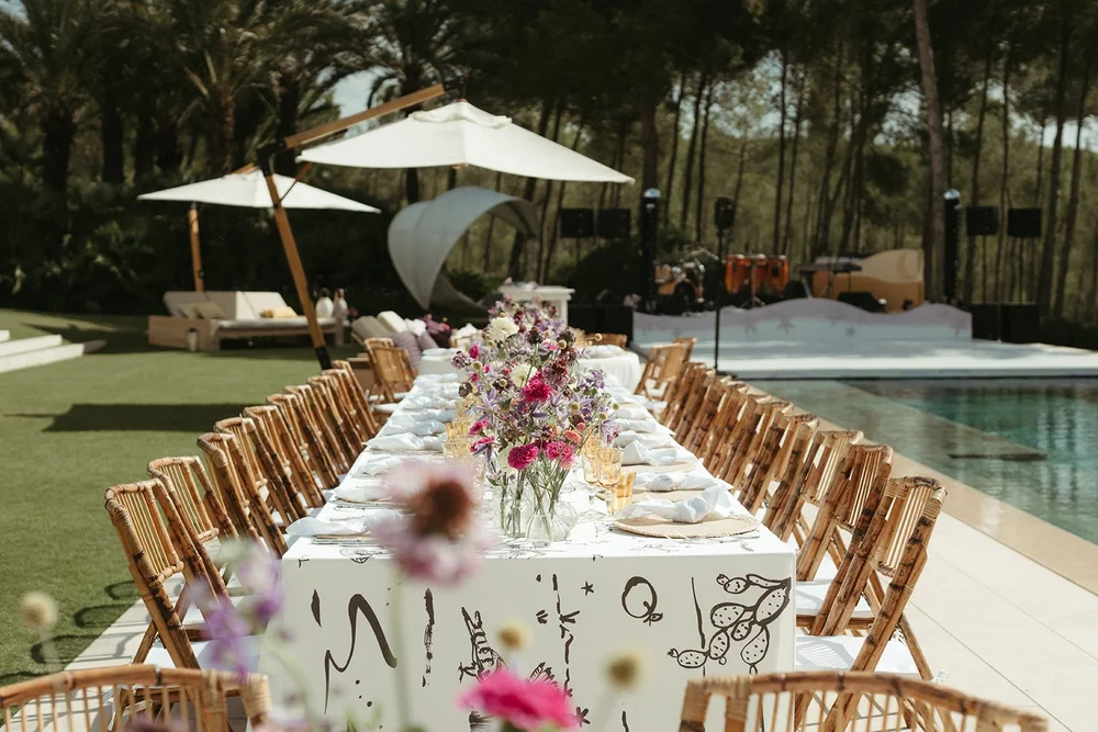 Mesa larga junto a la piscina en una boda en Ibiza