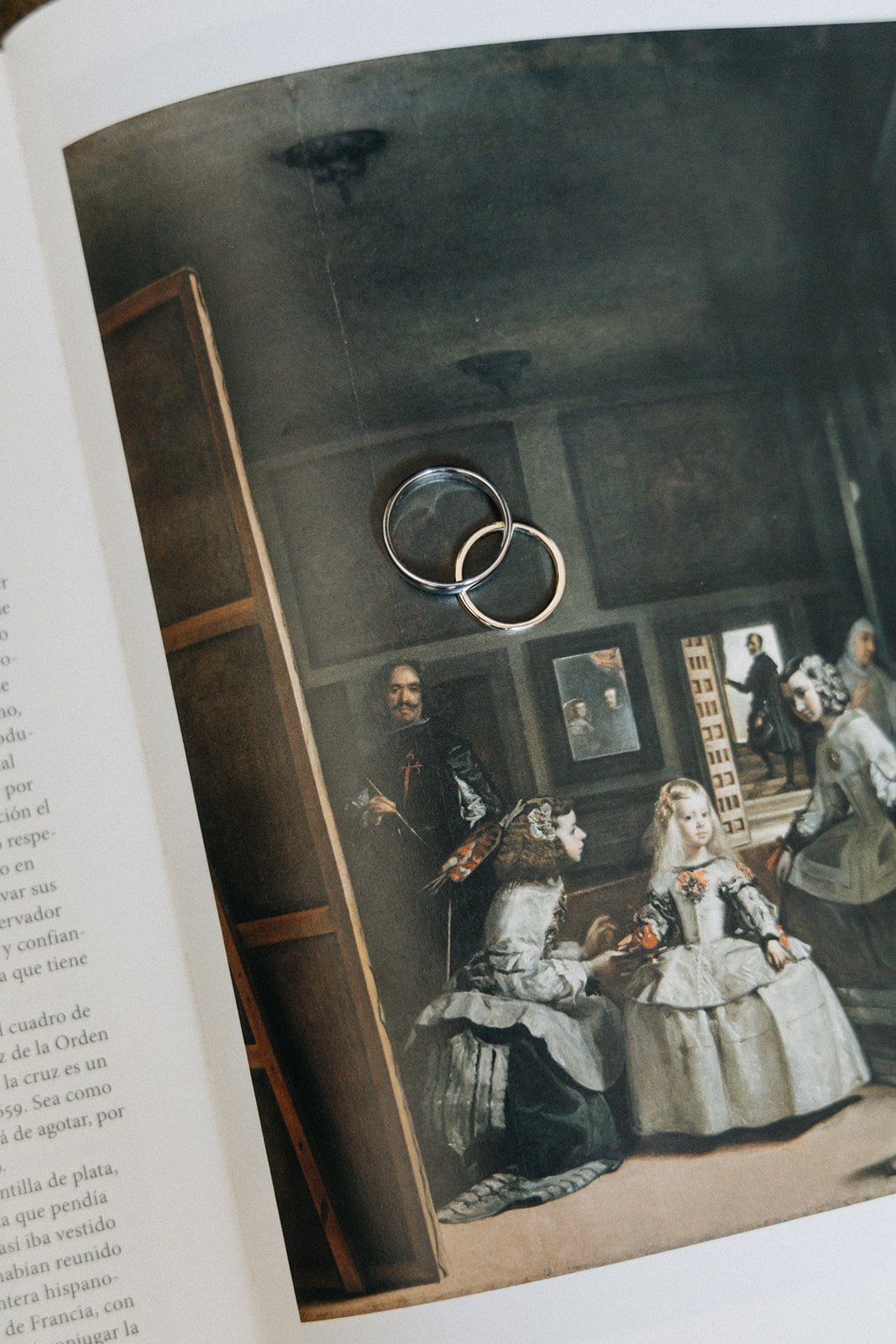 Alianzas de boda sobre un libro abierto por Las Meninas de Velázquez