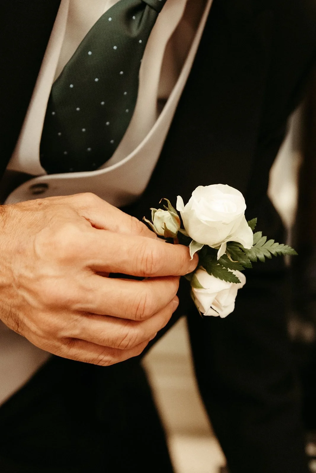 Prendido de rosas blancas en la solapa del novio