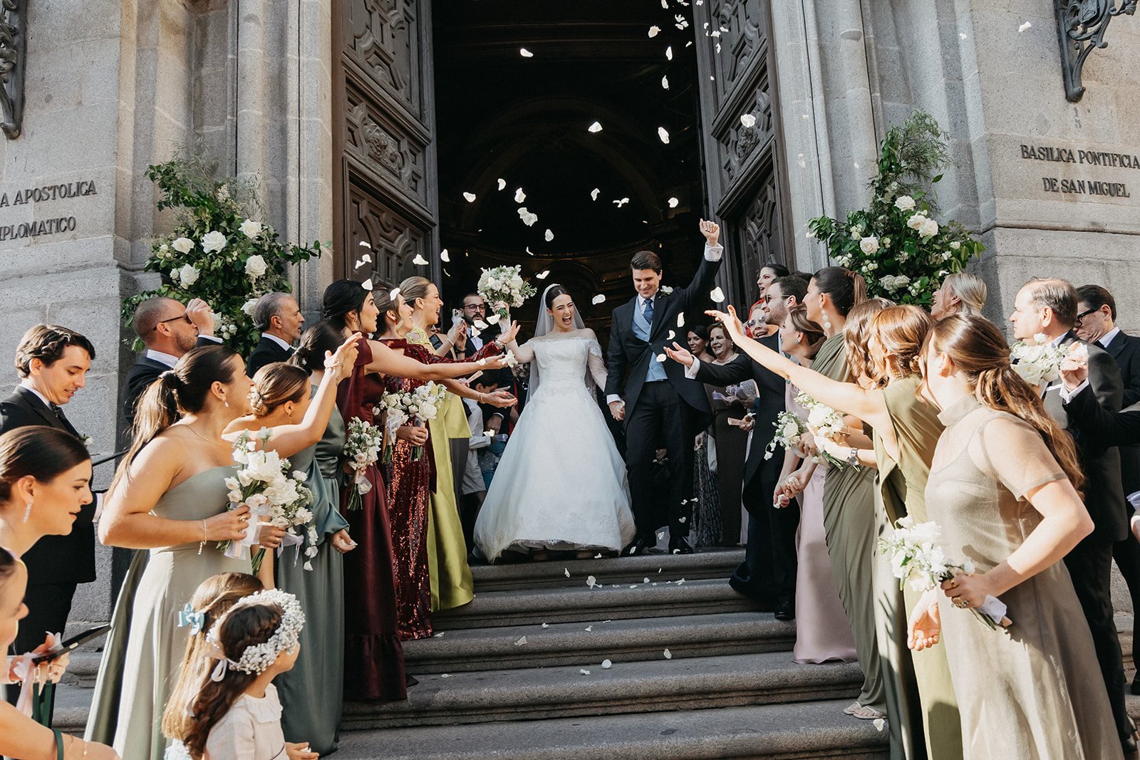 Salida de los novios entre pétalos en la escalinata de la basílica