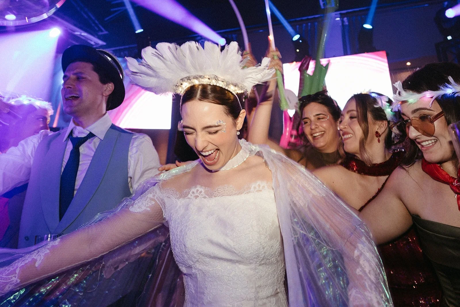 La novia baila con una corona de plumas en la fiesta