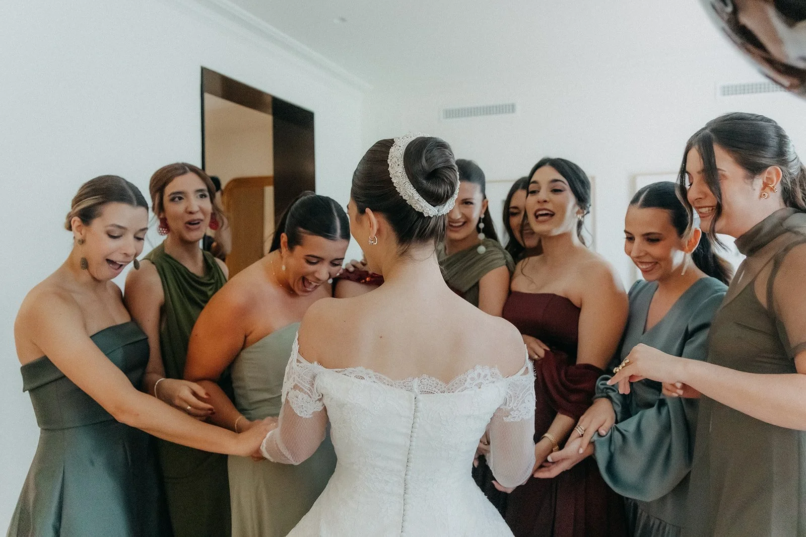The bride surrounded by her bridesmaids in the suite