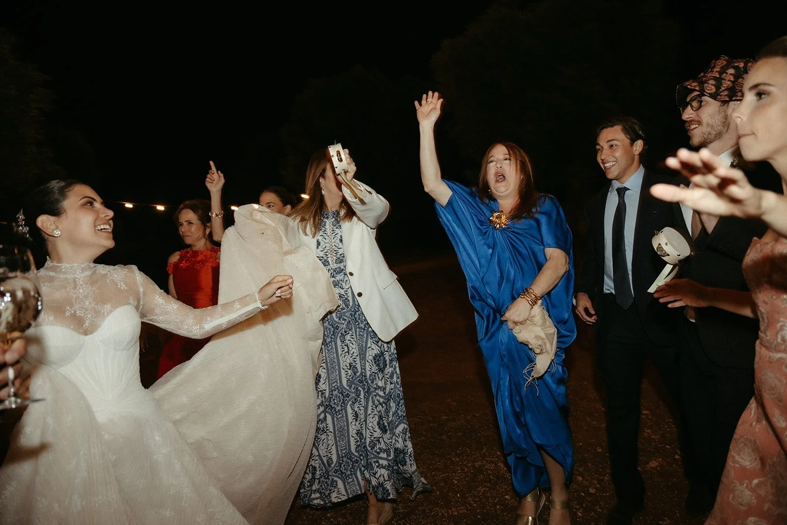 La novia baila con los invitados en la pista entre olivos