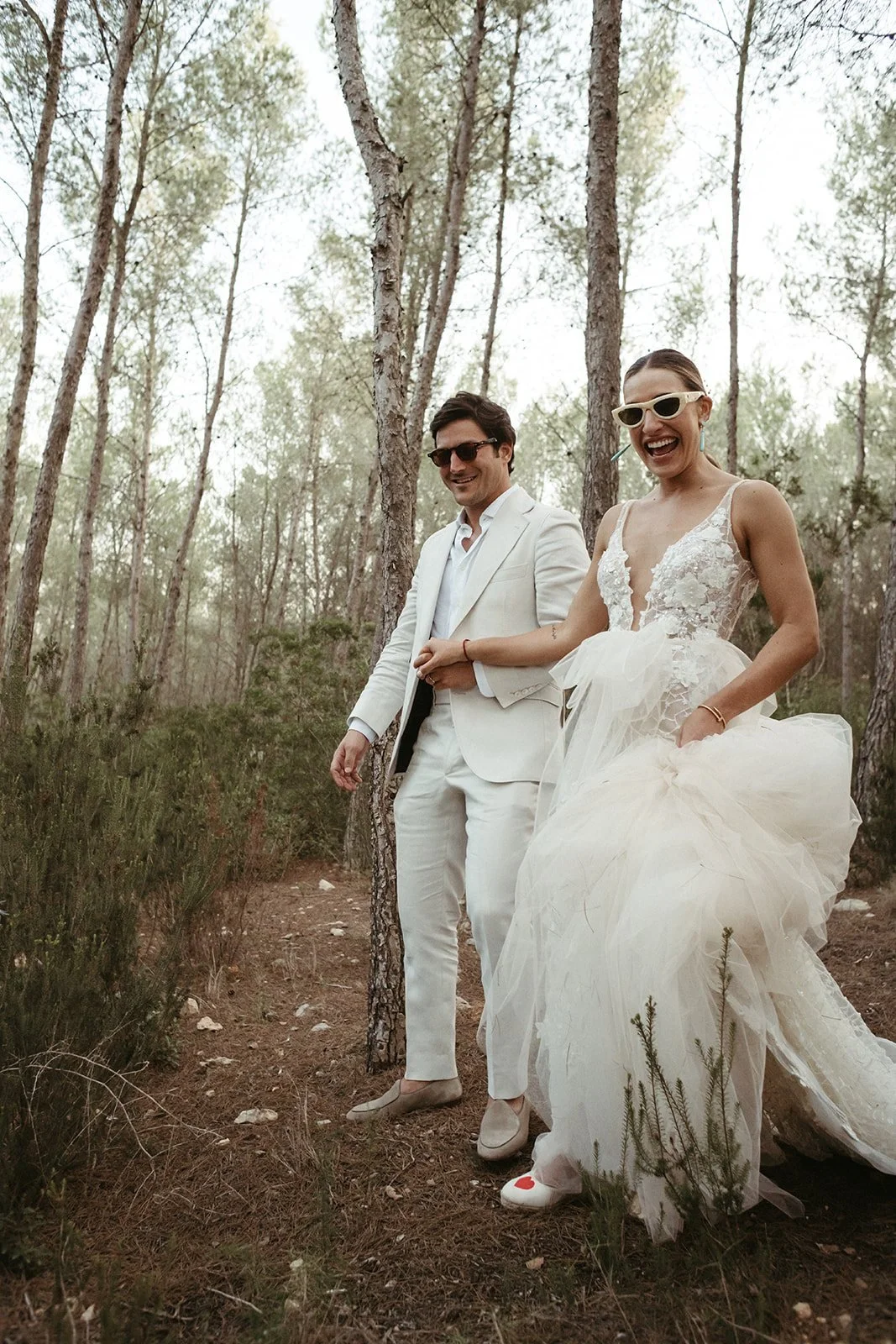 Los novios con gafas de sol caminando por el pinar
