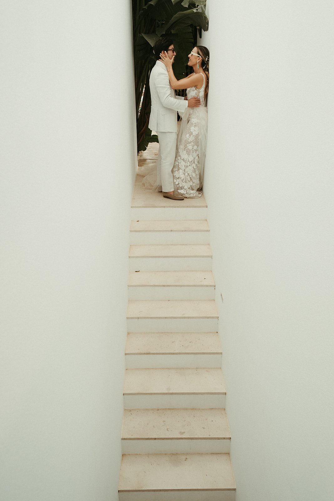 Los novios al fondo de un pasillo blanco de la villa