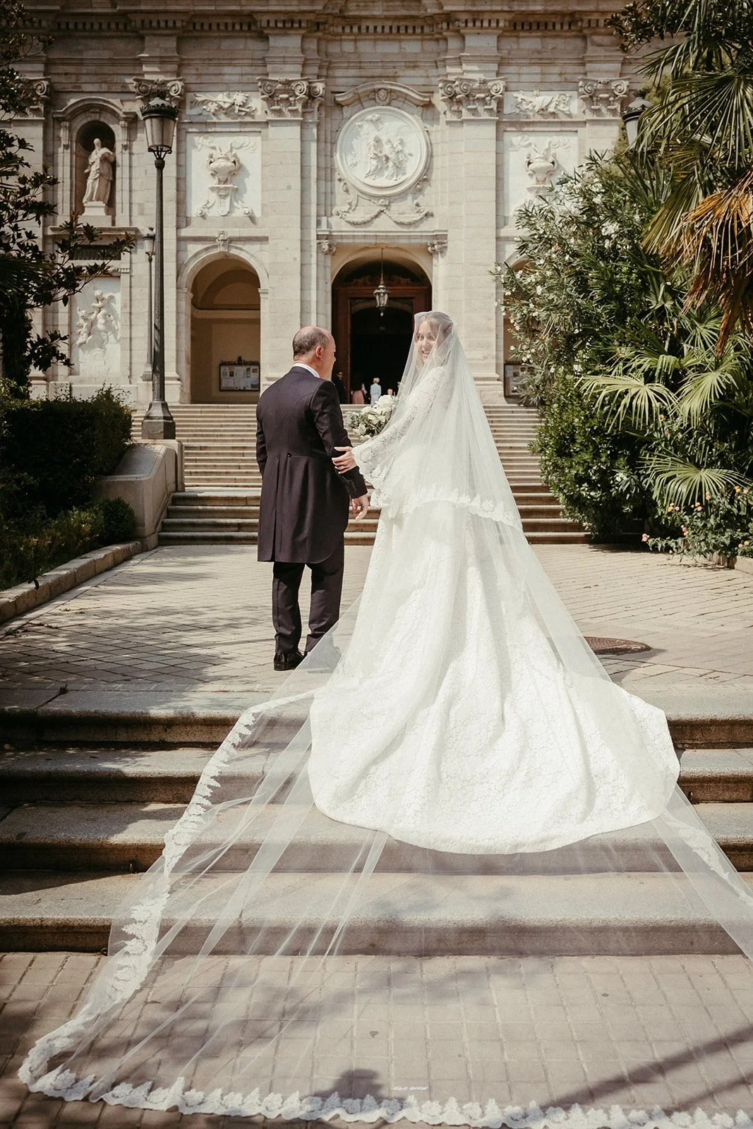 La novia sube la escalinata de Santa Bárbara con un velo catedral
