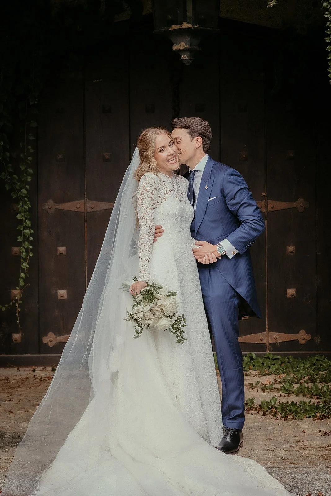 The couple kissing in front of an old wooden door at Finca El Campillo