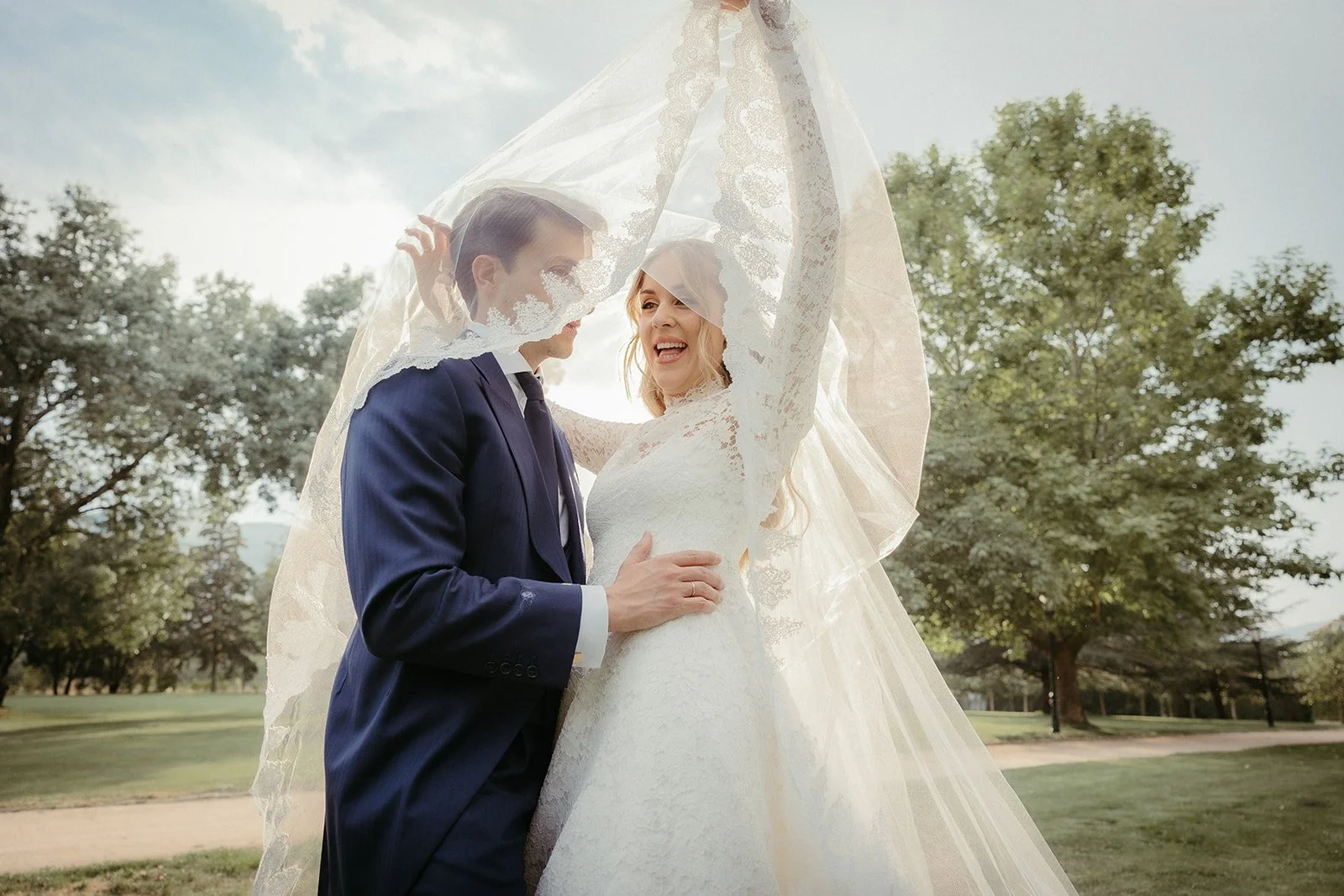 The couple beneath the veil in the estate gardens
