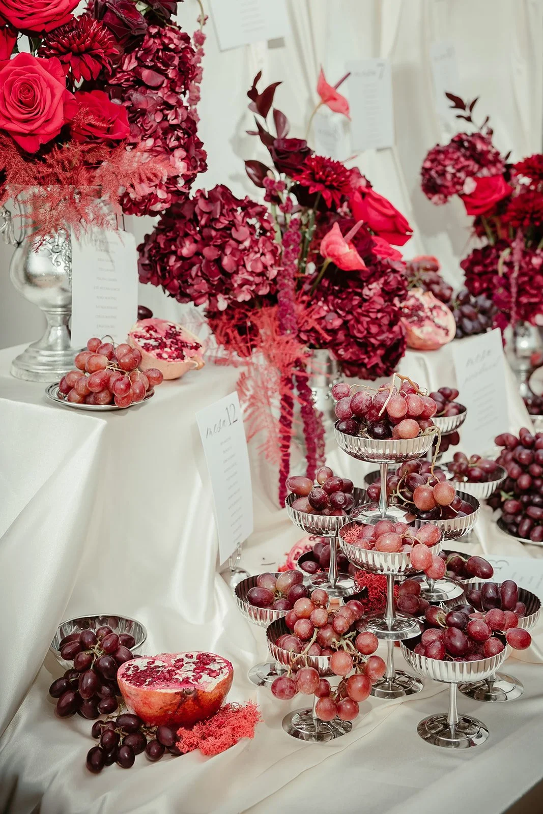 Seating plan with red flowers and pomegranates by The Green Room Flower Lab