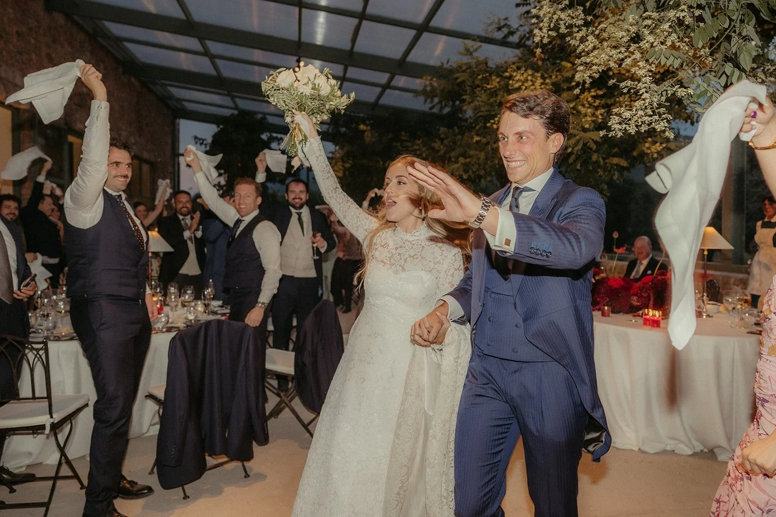The couple entering dinner among waving napkins