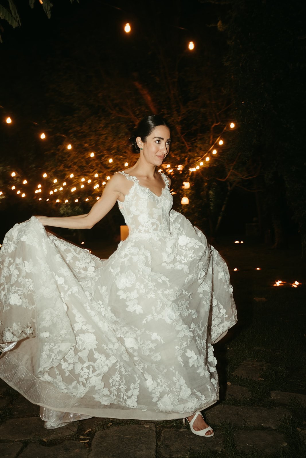La novia baila en el jardín iluminado de su boda en Venecia