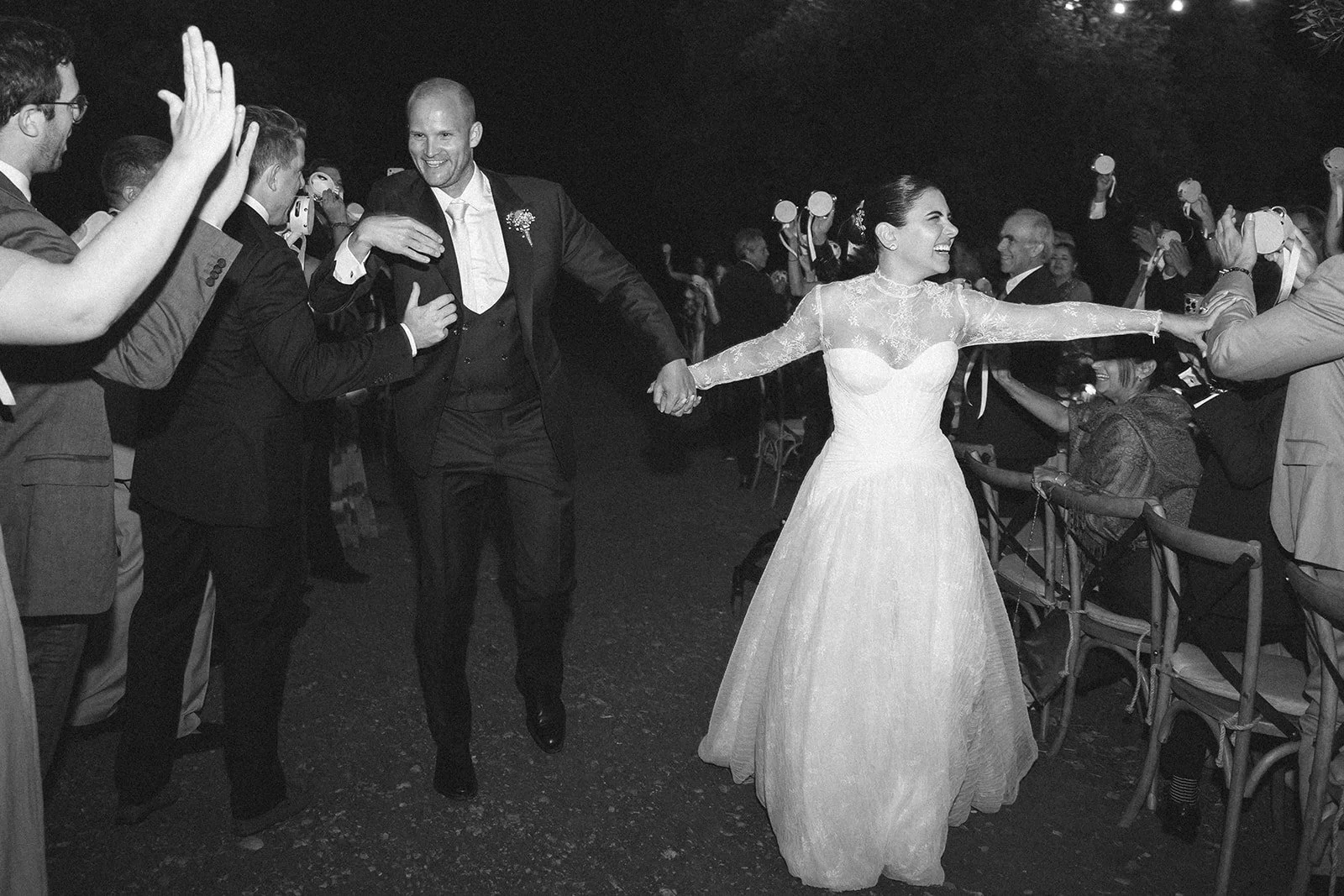 La novia baila entre las mesas de la cena en Puglia, en blanco y negro