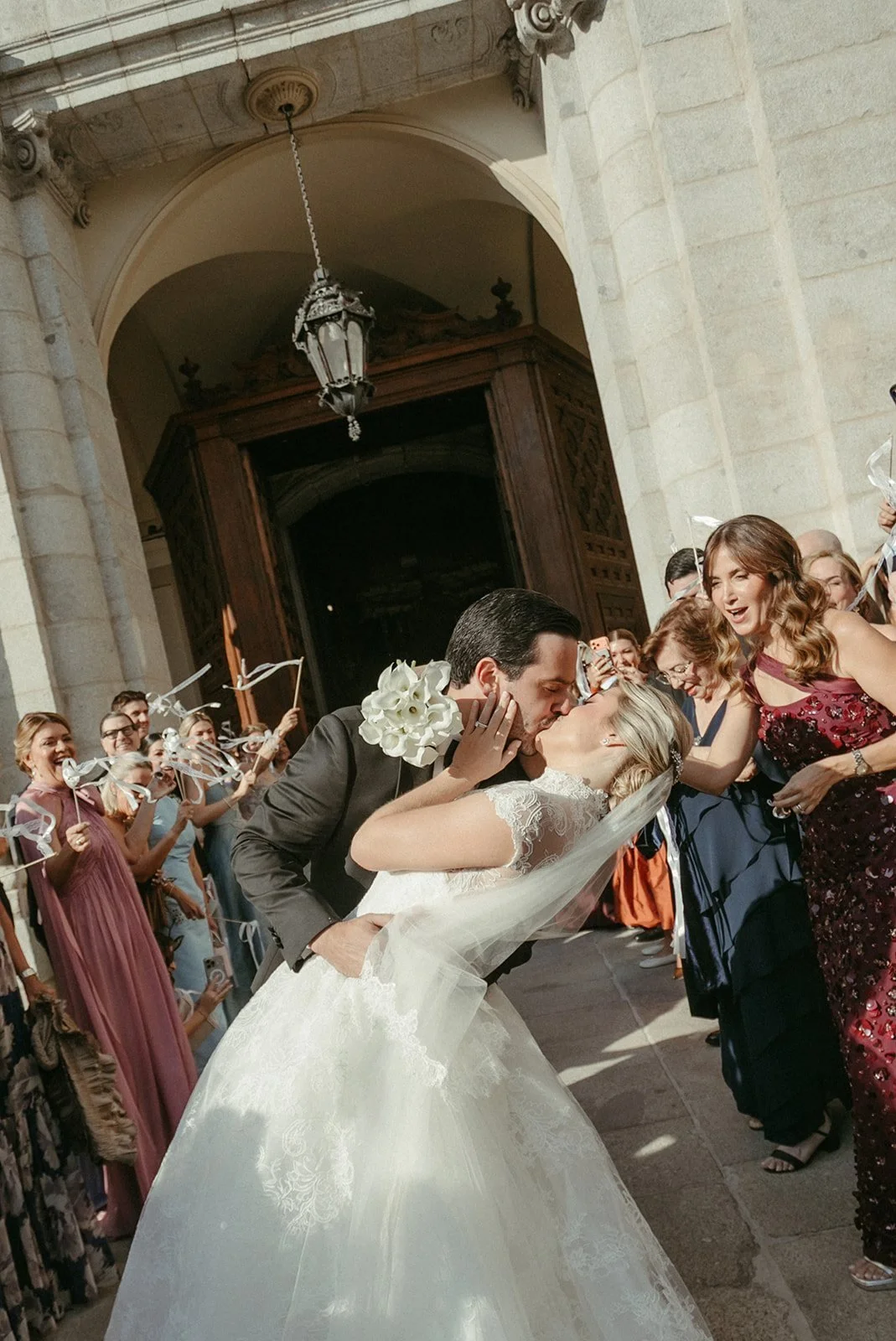 Bride leaving the church among guests and confetti in Madrid