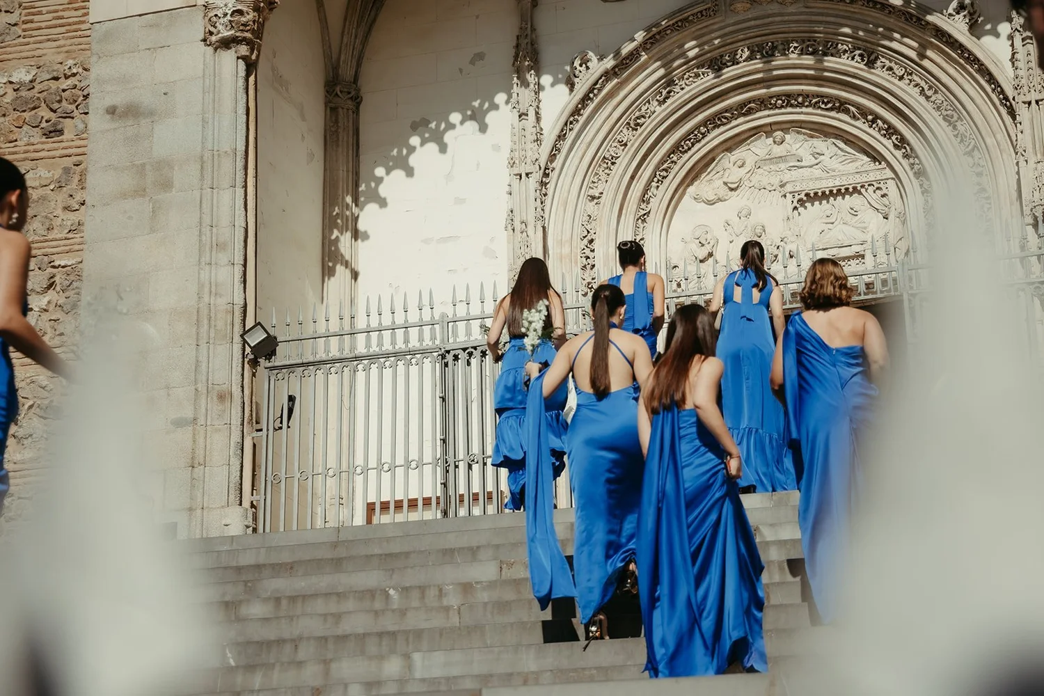 Bridesmaids in blue gowns at the Gothic doorway of San Jerónimo el Real, Madrid