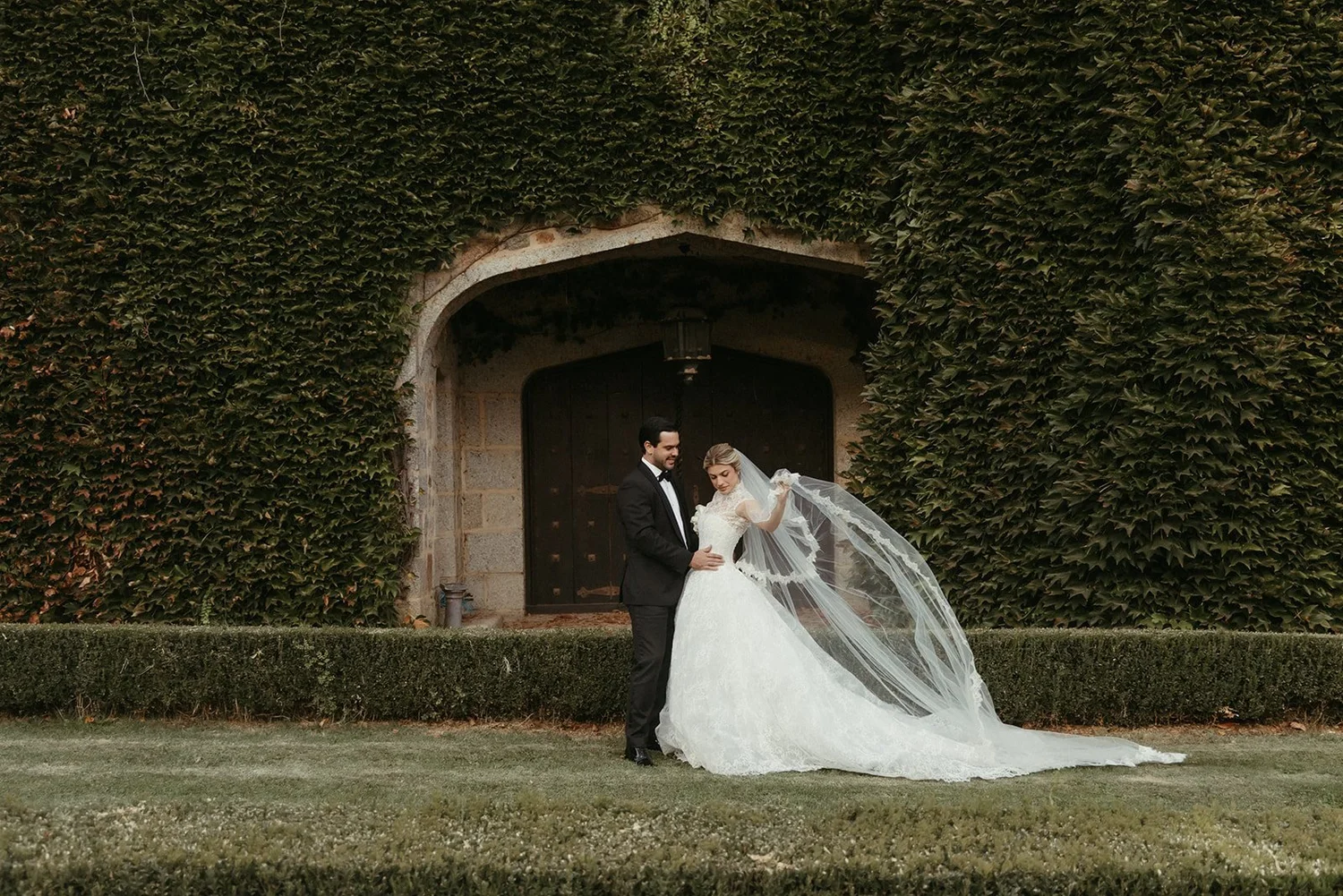 Bride and groom by an ivy-covered doorway near El Escorial, Madrid