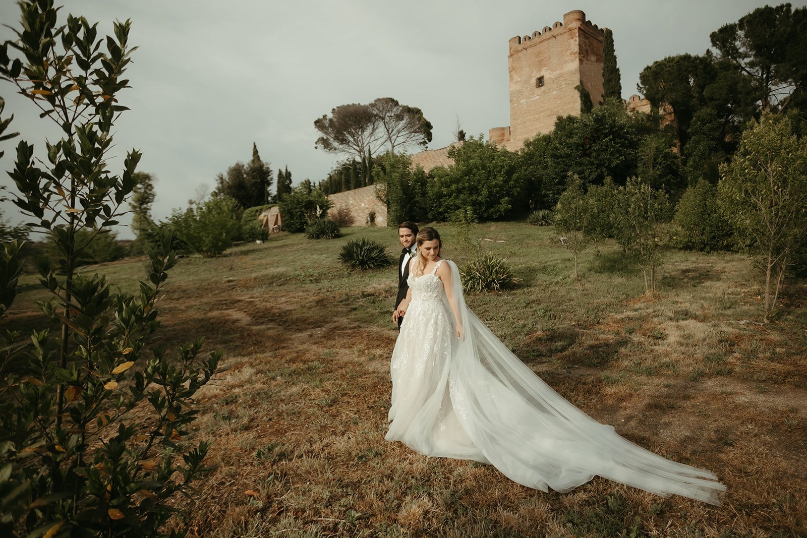 Annie y Romek en una colina con una torre al fondo