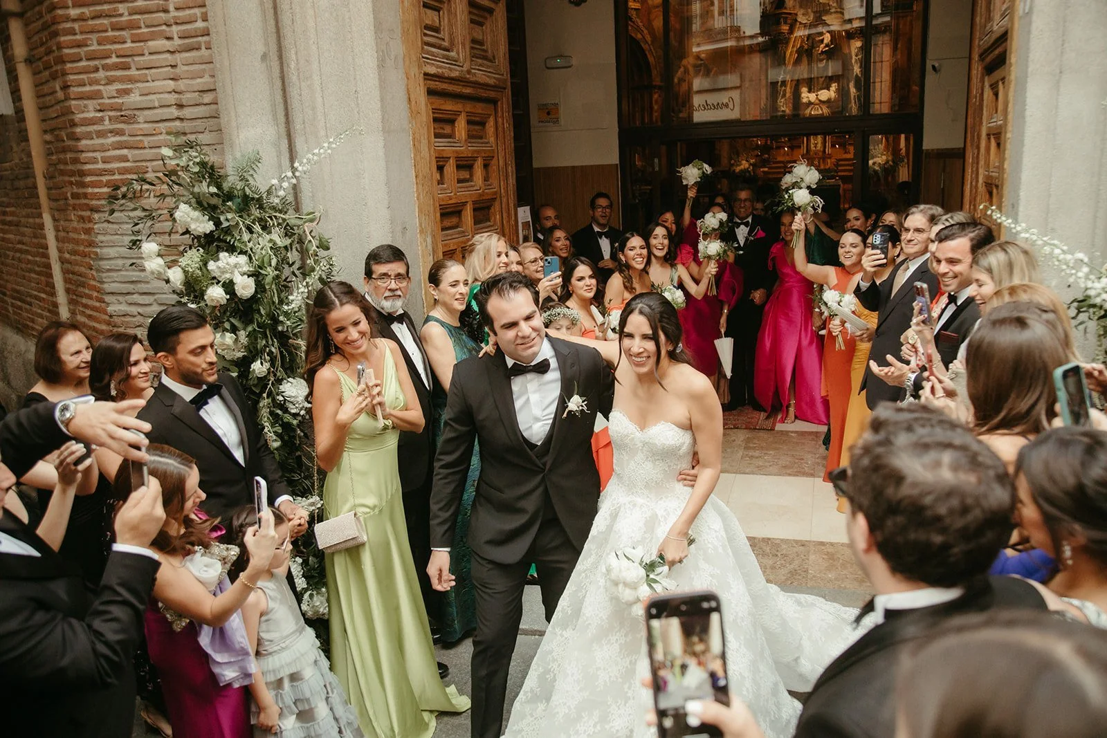Los invitados graban con el móvil la salida de Camila y Carlos de la iglesia de San Antonio de los Alemanes, en Madrid